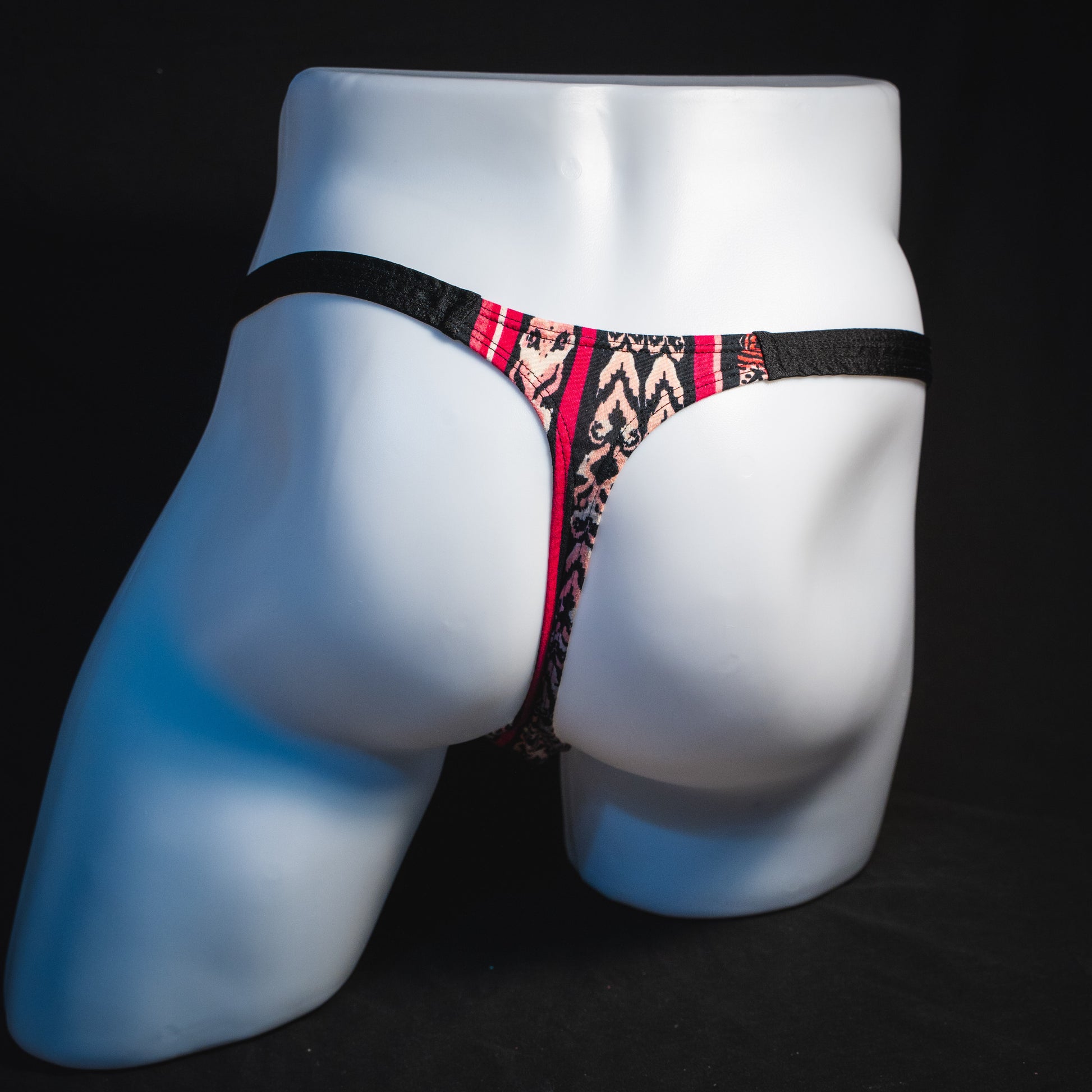 Men's pink bohemian striped thong underwear, classic cut, full rear view.