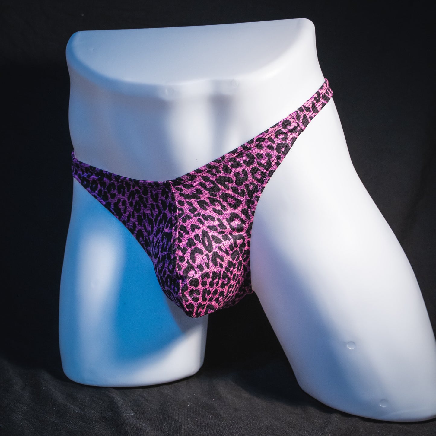 Men's pink leopard thong underwear, classic cut, full angled front view.