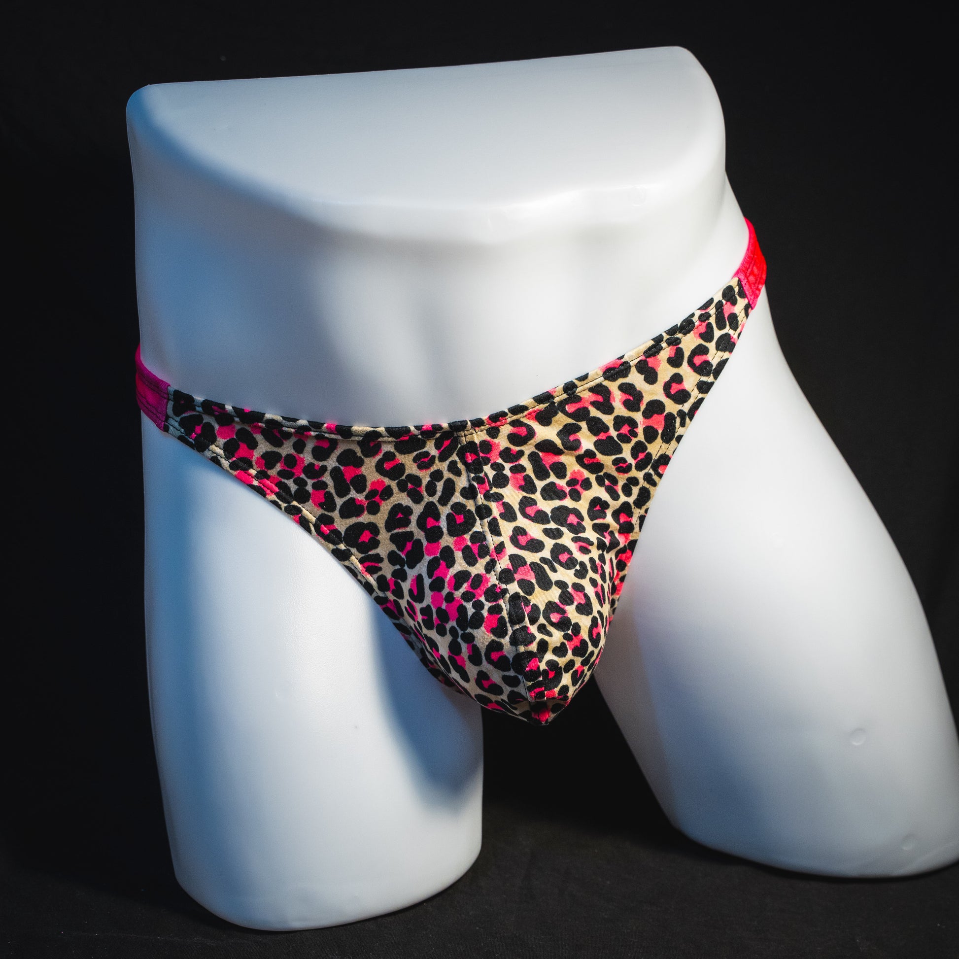 Men's pink leopard thong underwear, classic cut, full front view.