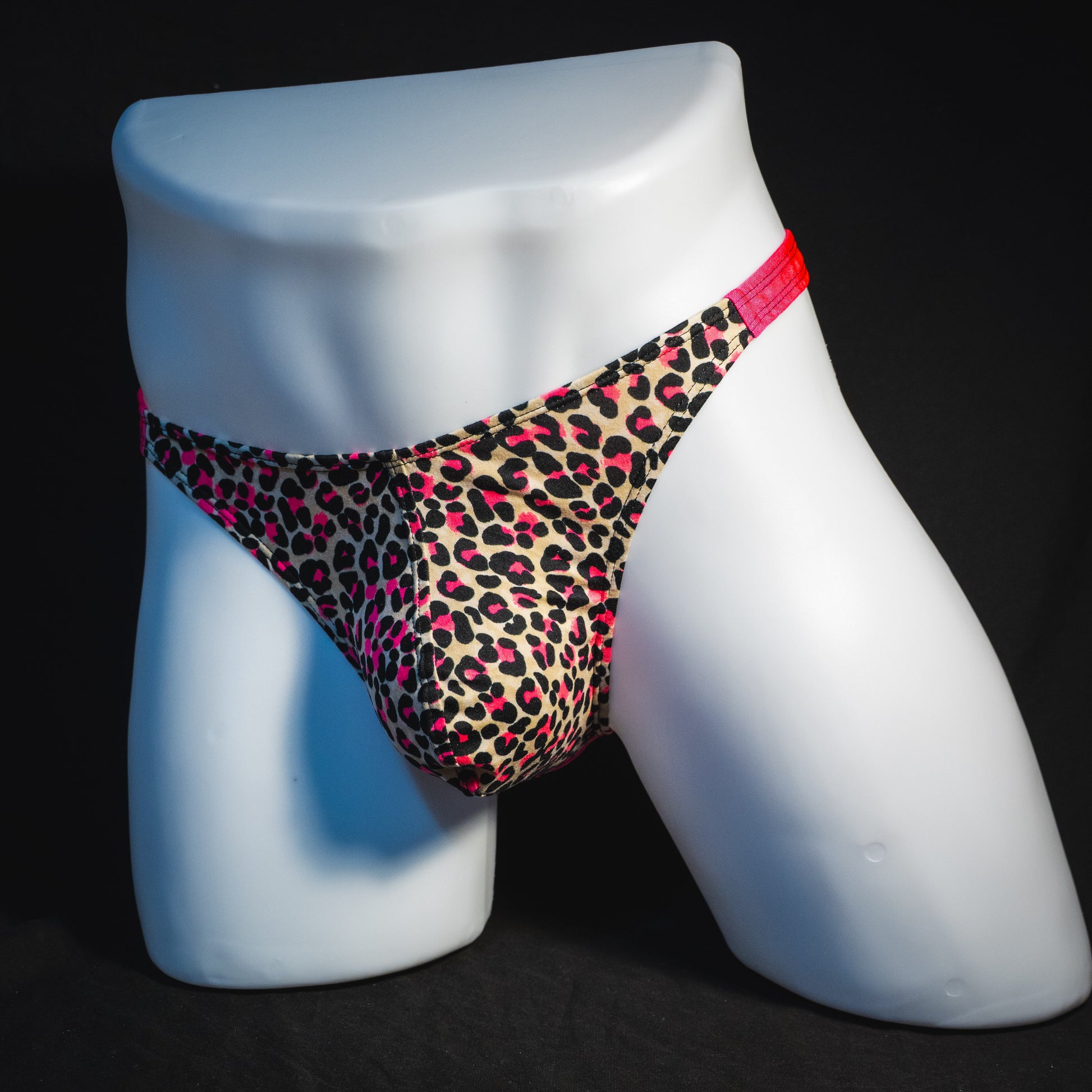 Men's pink leopard thong underwear, classic cut, full front angled view.