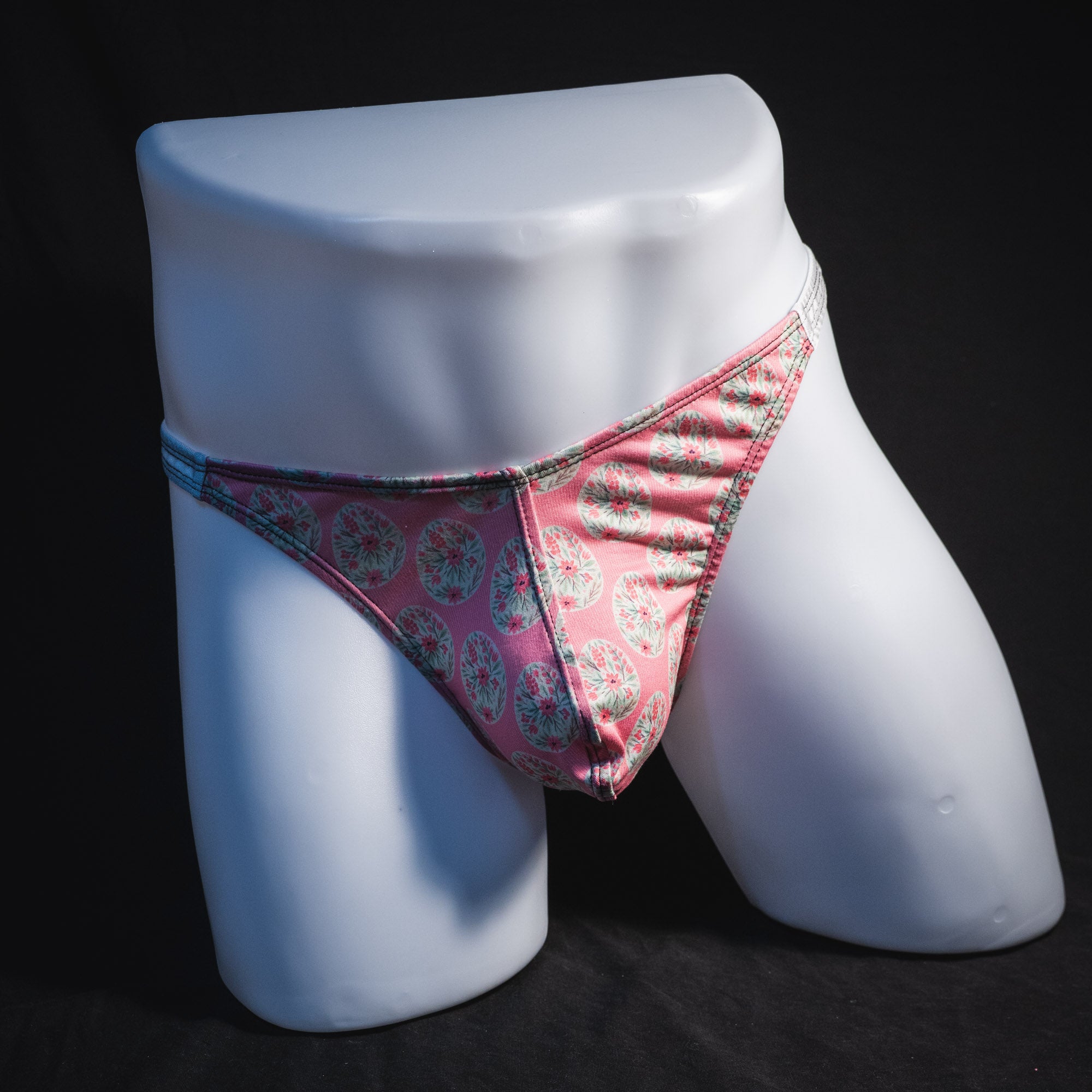 Men's pink painted easter eggs thong underwear, classic cut, full front view.