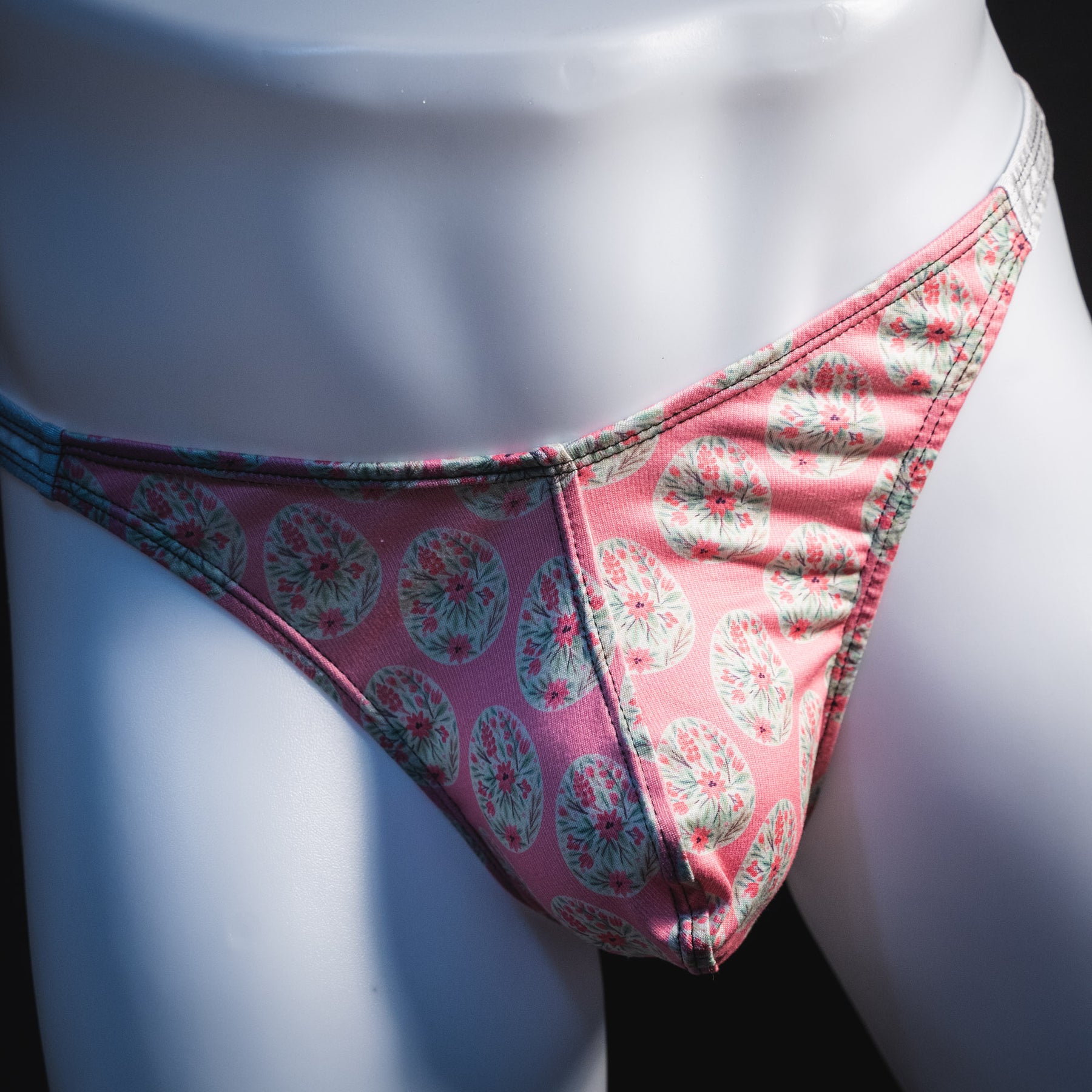 Men's pink painted easter eggs thong underwear, classic cut, front view.