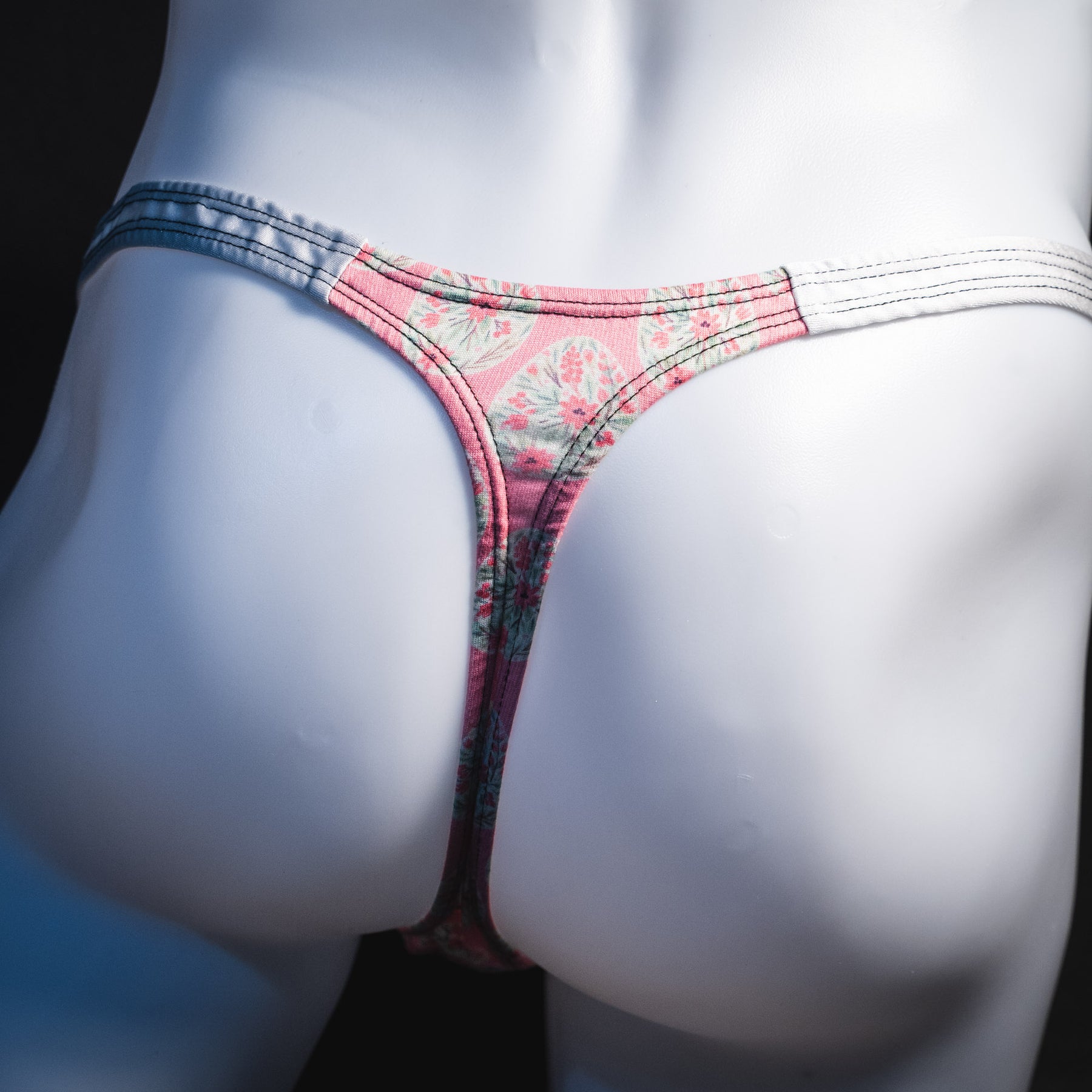 Men's pink painted easter eggs thong underwear, classic cut, rear view.