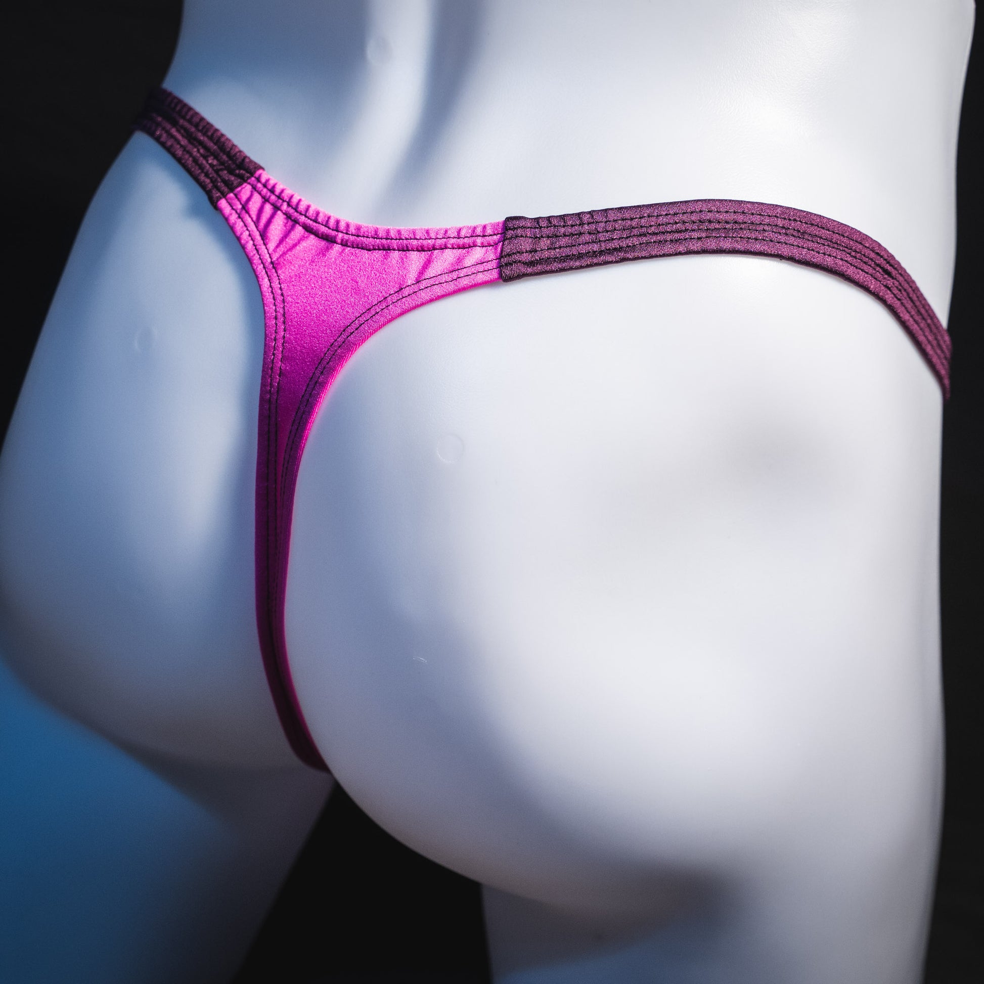 Men's pink and purple thong underwear, classic cut, rear angled view.