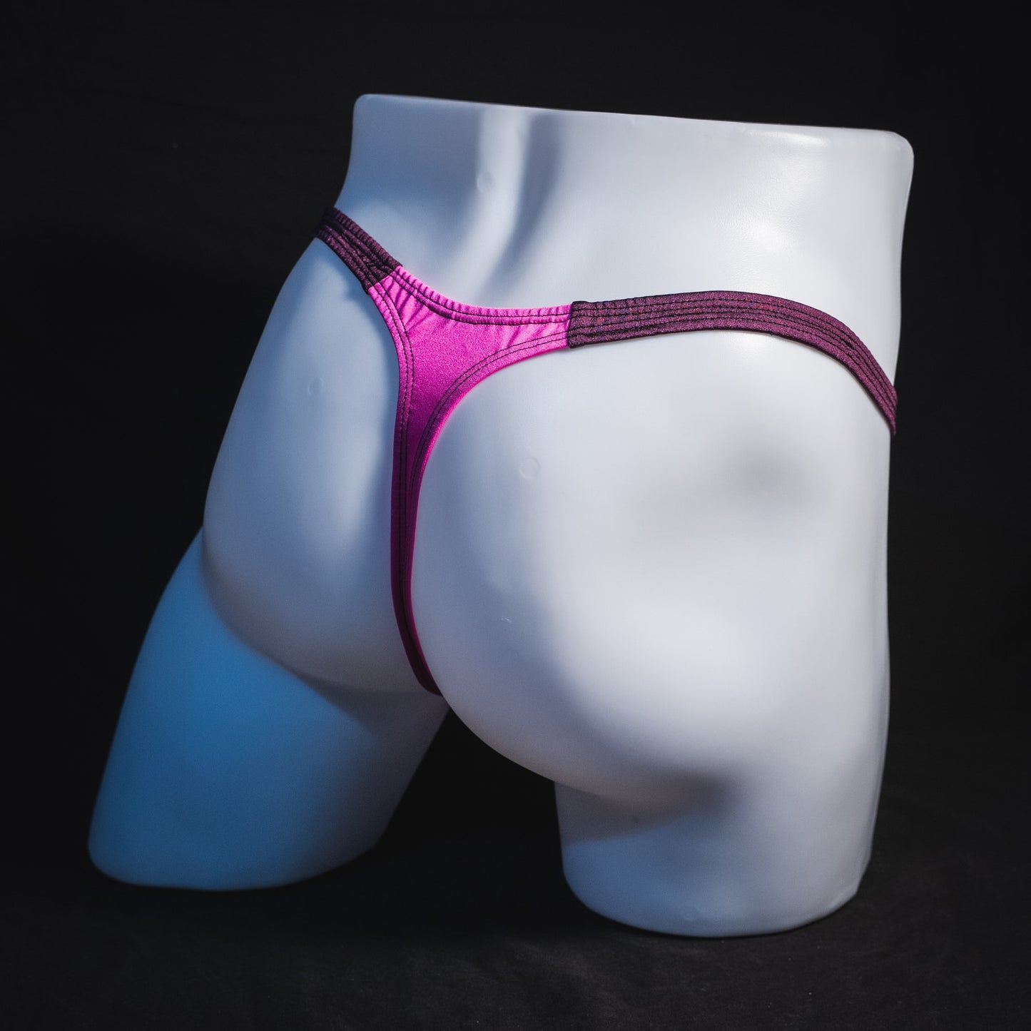 Men's pink and purple thong underwear, classic cut, full angled rear view.