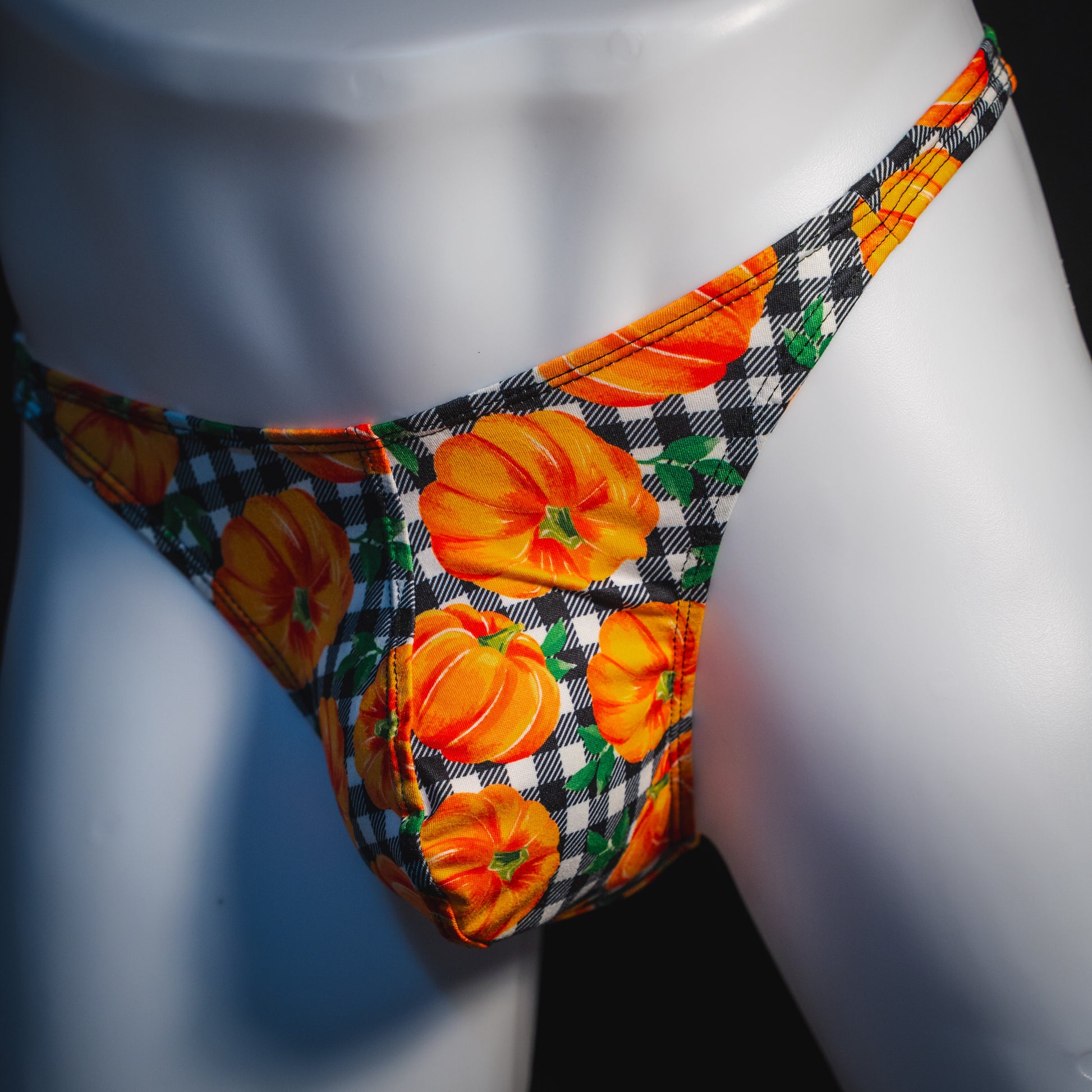 Men's pumpkin and plaid thong underwear, classic cut, angled front view.
