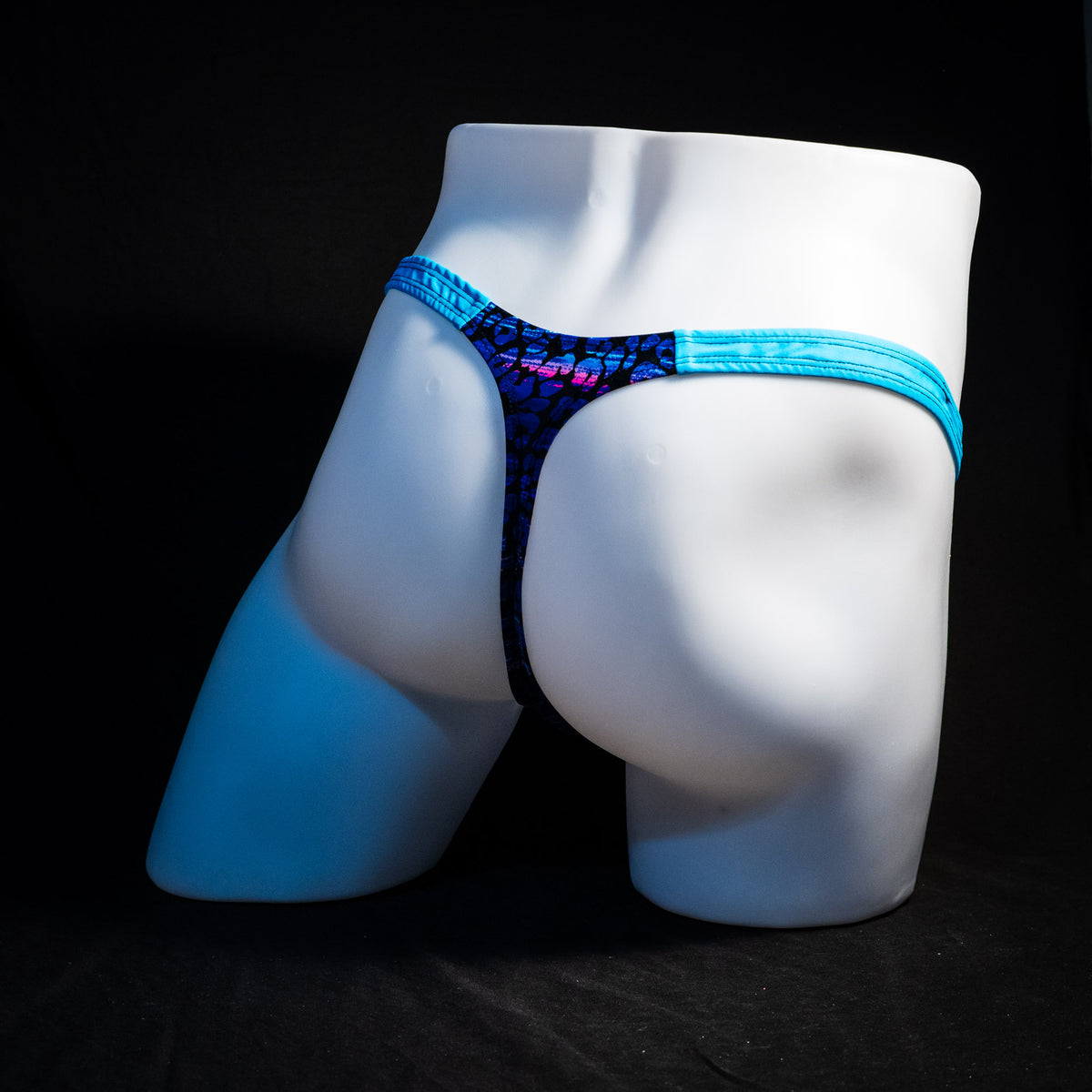Men's purple and blue cheetah thong underwear, classic cut, full rear angled view.