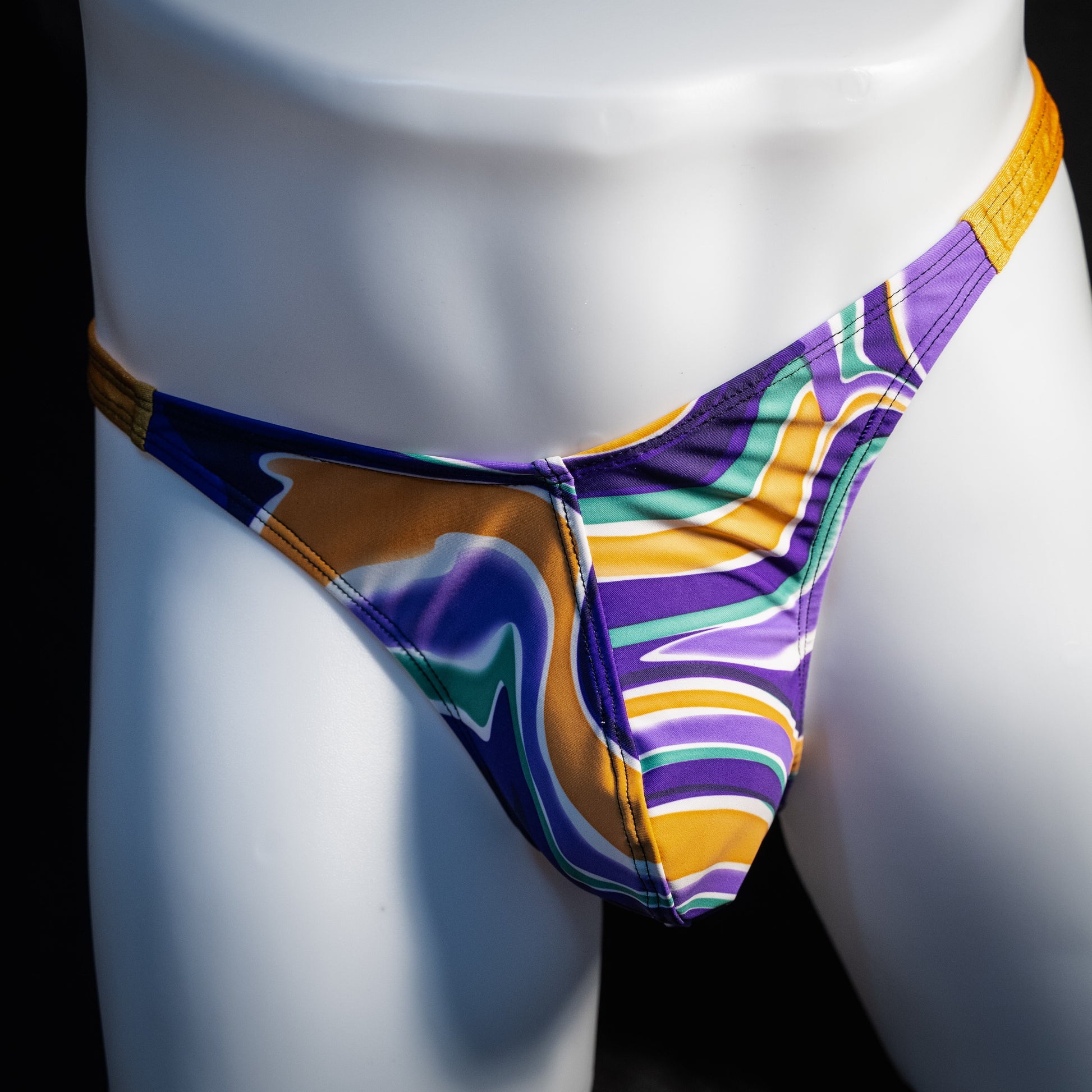 Men's purple and copper psychedelic thong underwear, classic cut, front view.