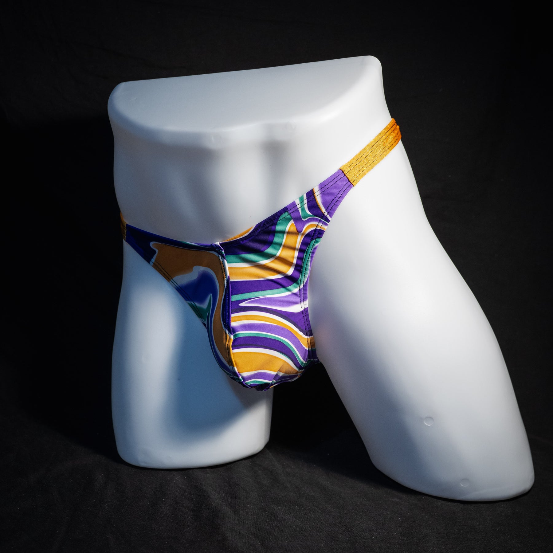 Men's purple and copper psychedelic thong underwear, classic cut, front view.