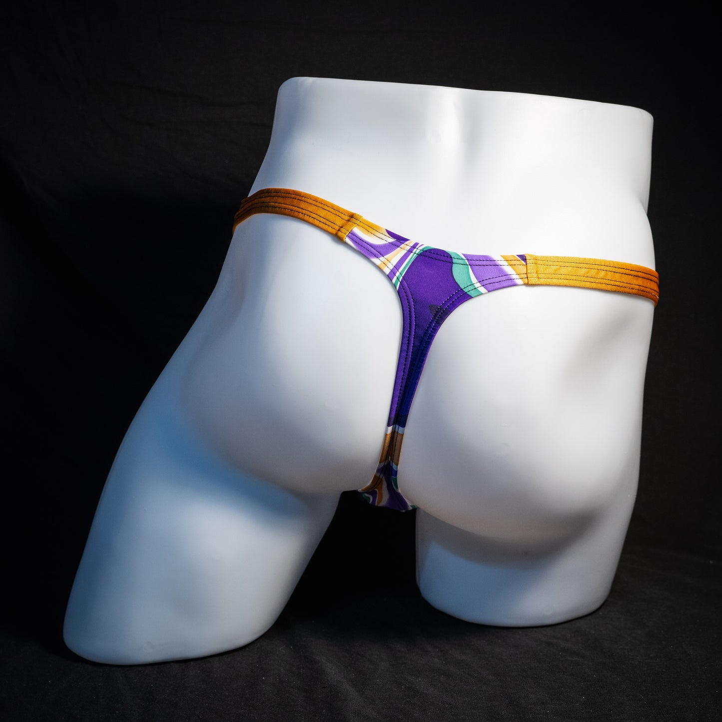 Men's purple and copper psychedelic thong underwear, classic cut, rear view.