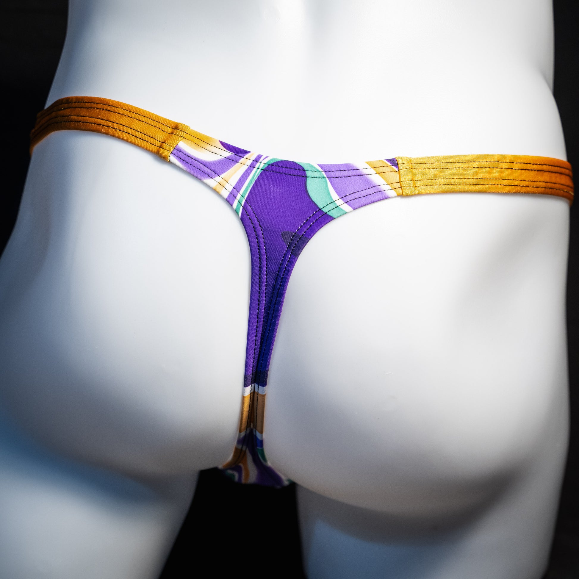 Men's purple and copper psychedelic thong underwear, classic cut, rear view.