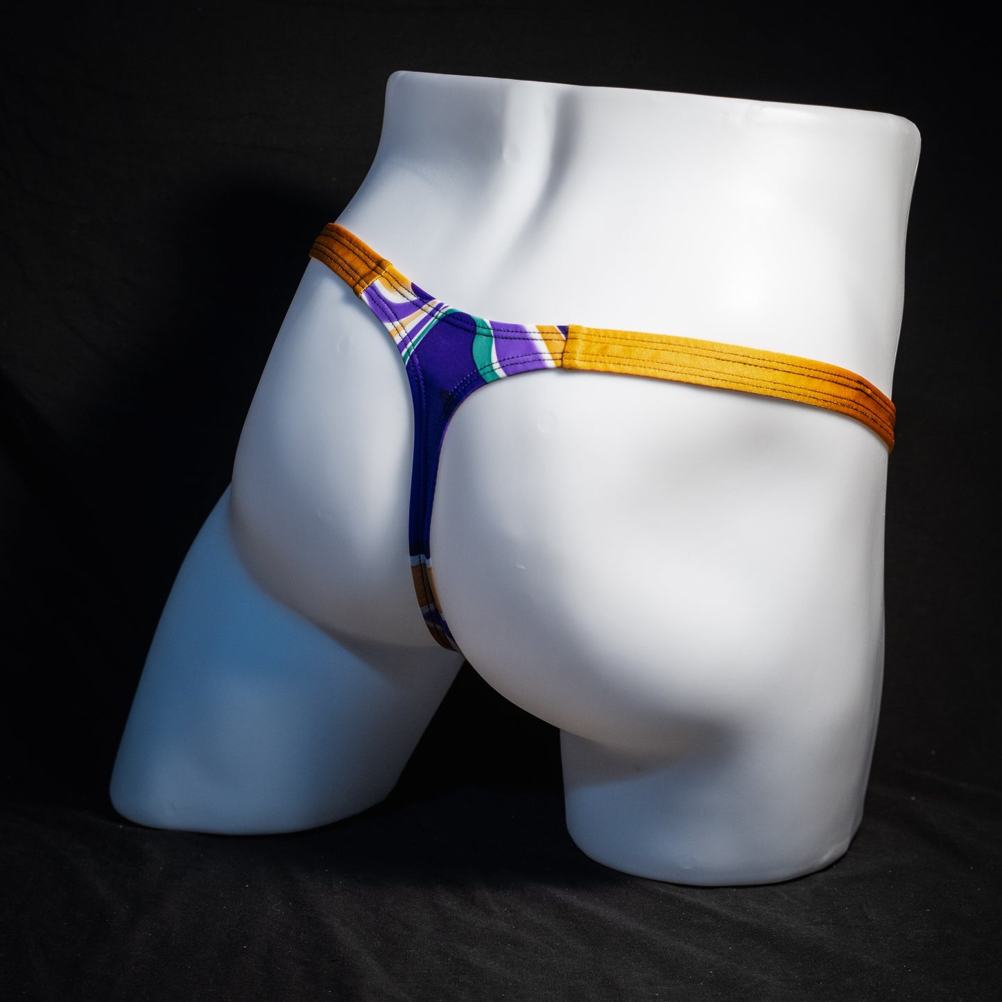 Men's purple and copper psychedelic thong underwear, classic cut, rear view.