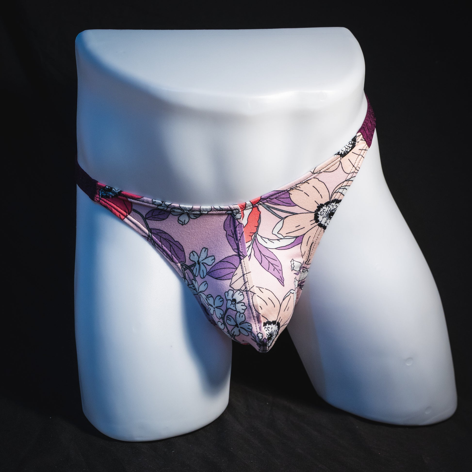 Men's purple floral thong underwear, classic cut, full front view.