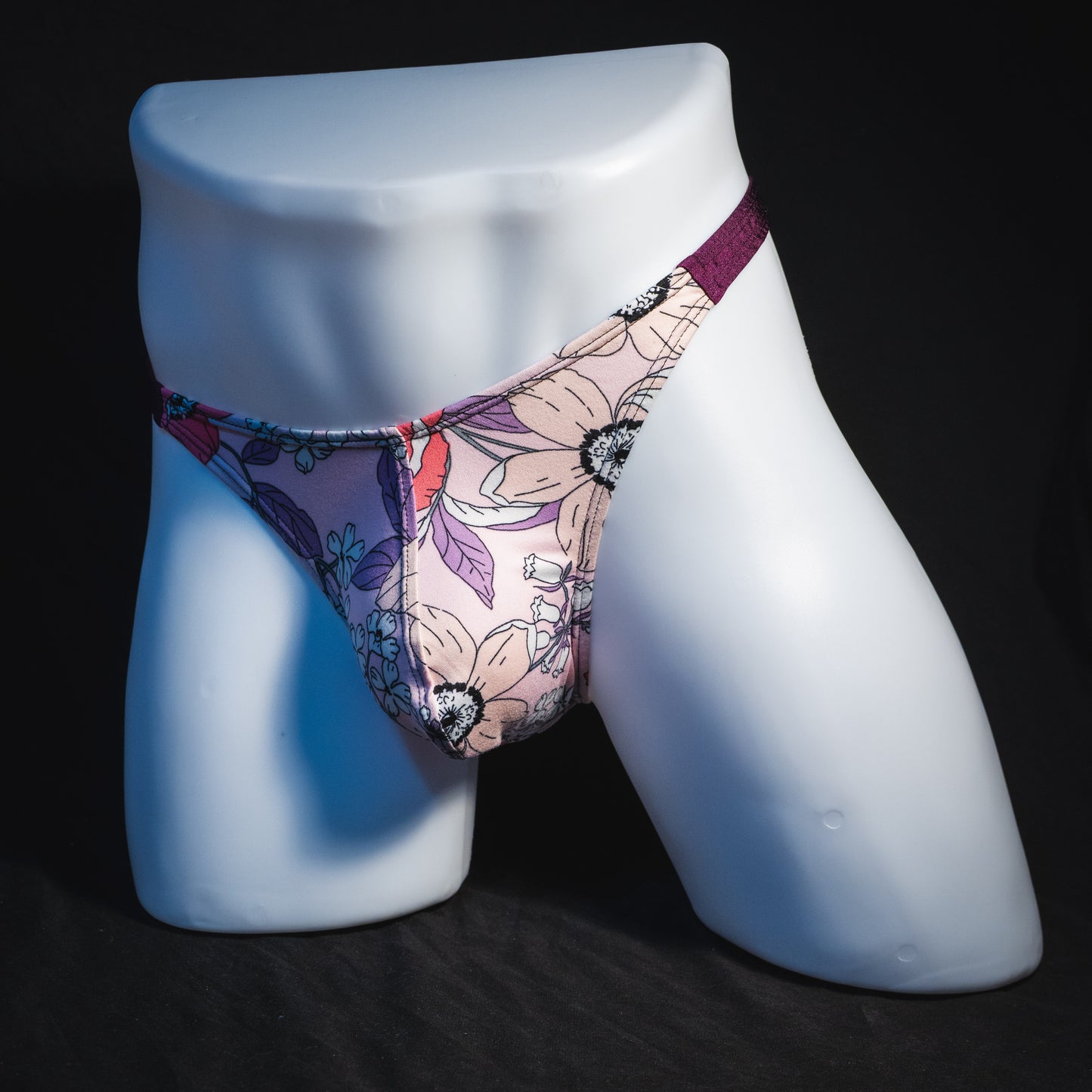 Men's purple floral thong underwear, classic cut, full angled front view.
