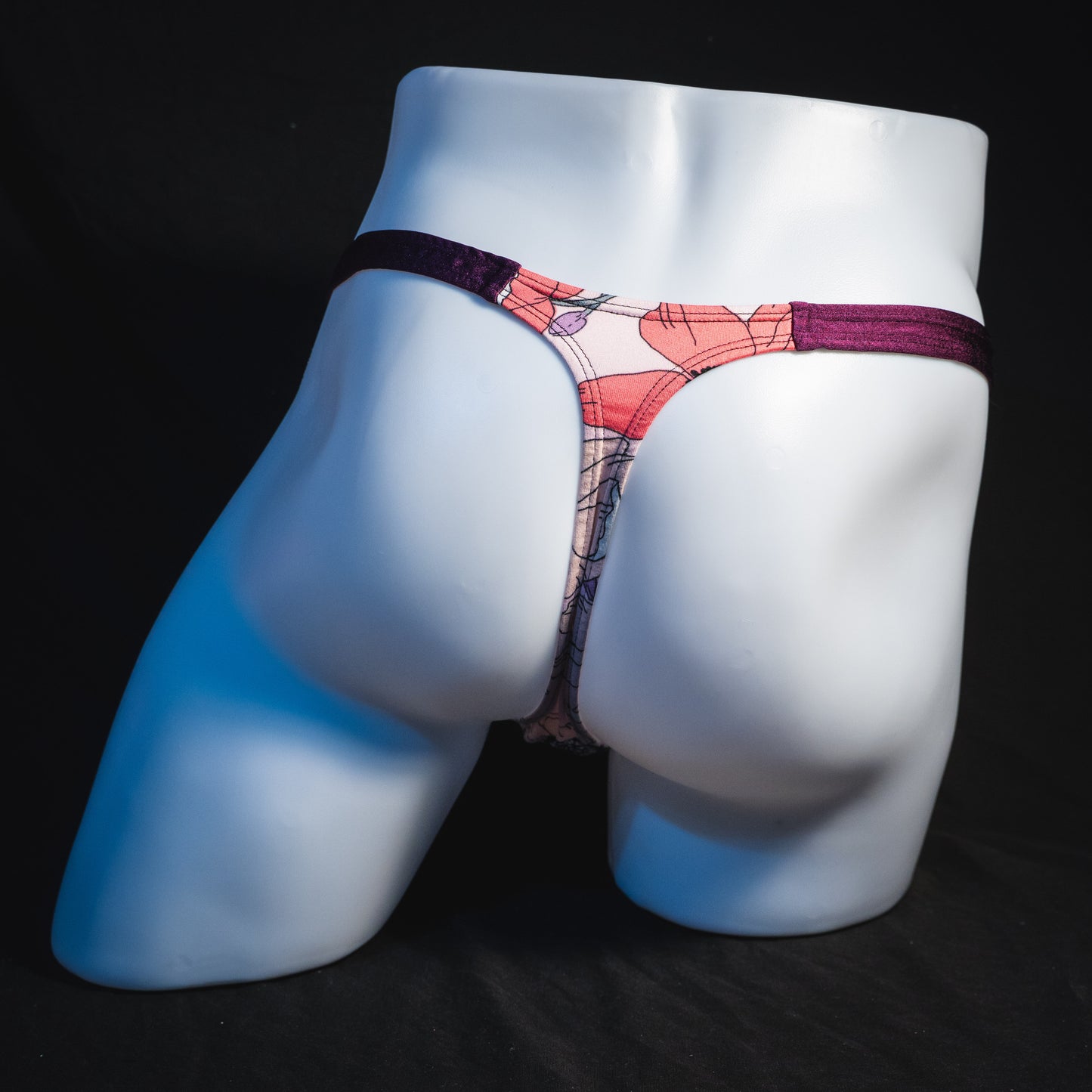 Men's purple floral thong underwear, classic cut, full rear view.