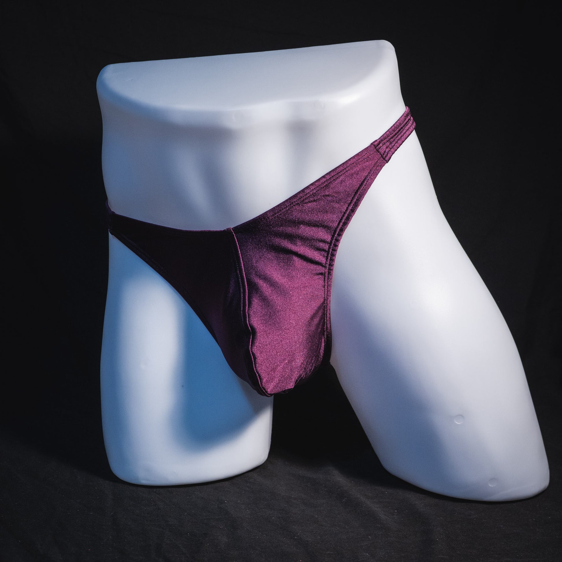 Men's solid purple thong underwear, classic cut, full angled front view.