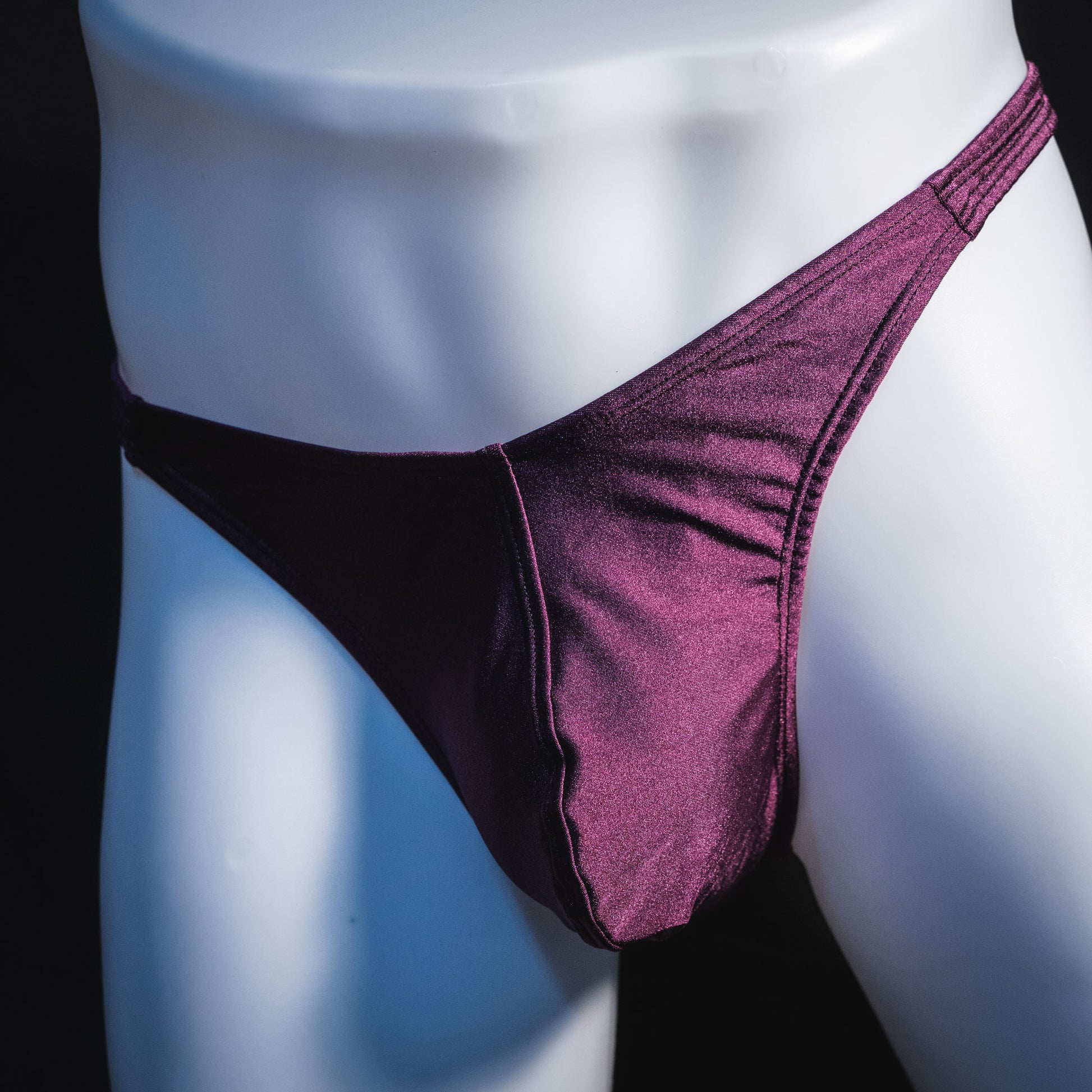 Men's solid purple thong underwear, classic cut, front angled view.