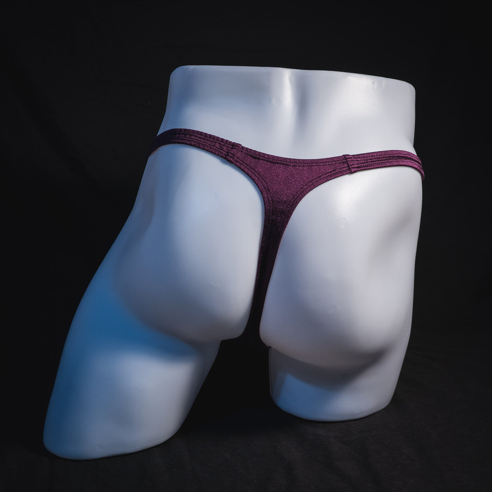 Men's solid purple thong underwear, classic cut, full rear view.