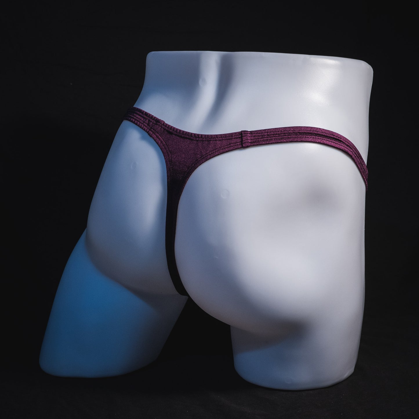 Men's solid purple thong underwear, classic cut, full angled rear view.