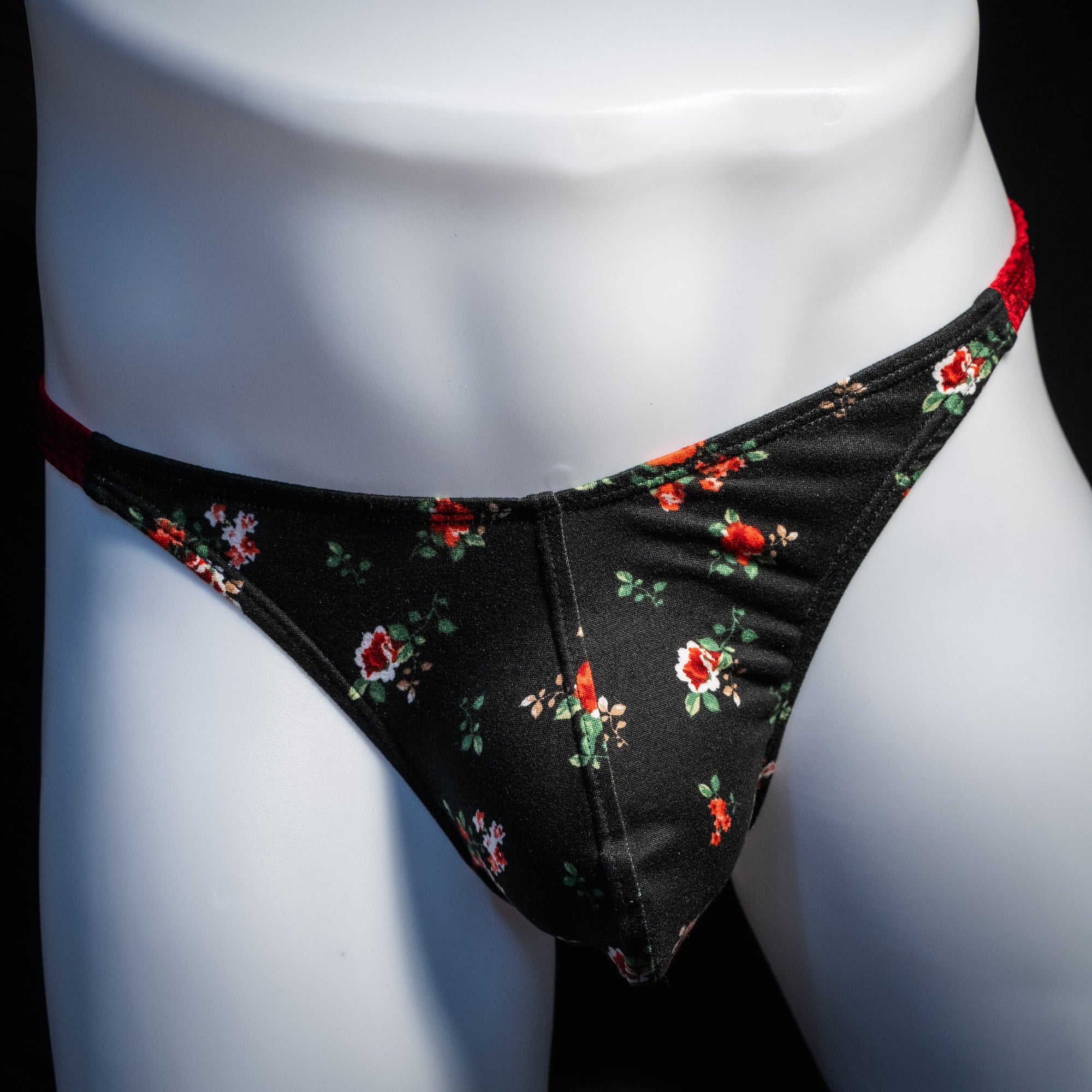 Men's red and black floral thong underwear, classic cut, front view.