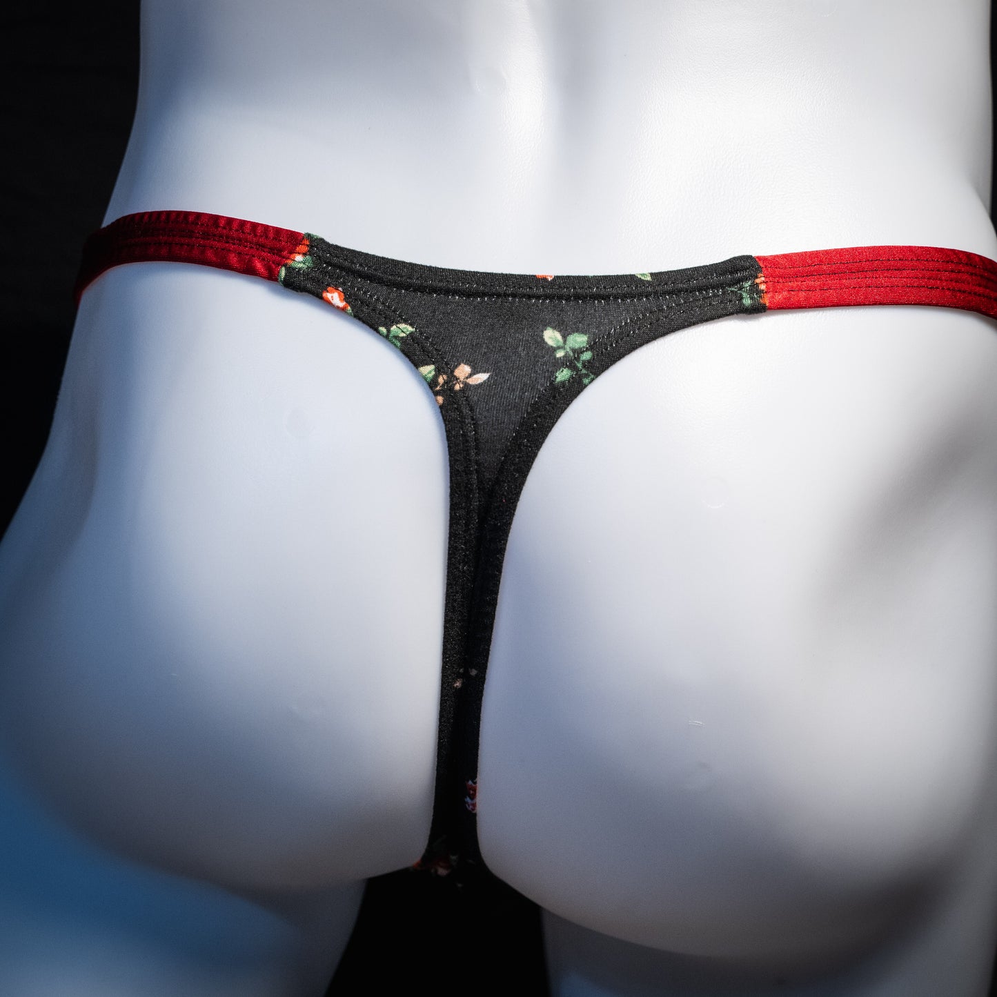 Men's red and black floral thong underwear, classic cut, rear view.