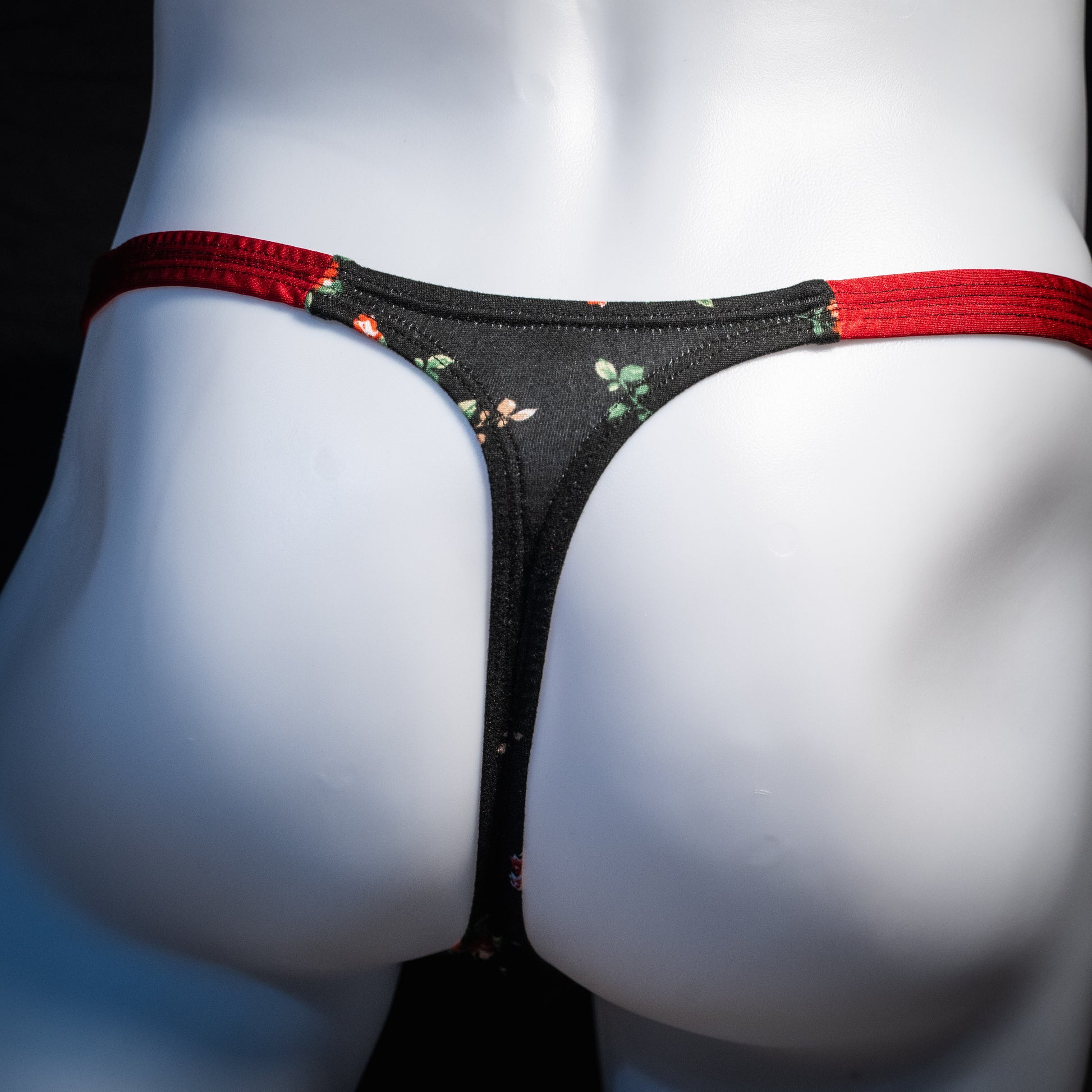 Men's red and black floral thong underwear, classic cut, rear view.