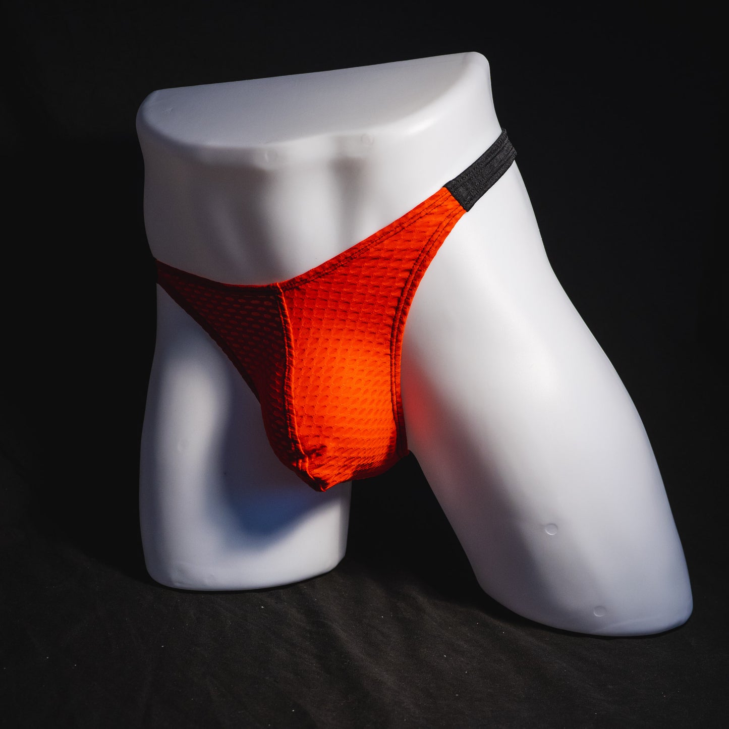 Men's red and black athletic mesh thong underwear, classic cut, full angled front view.