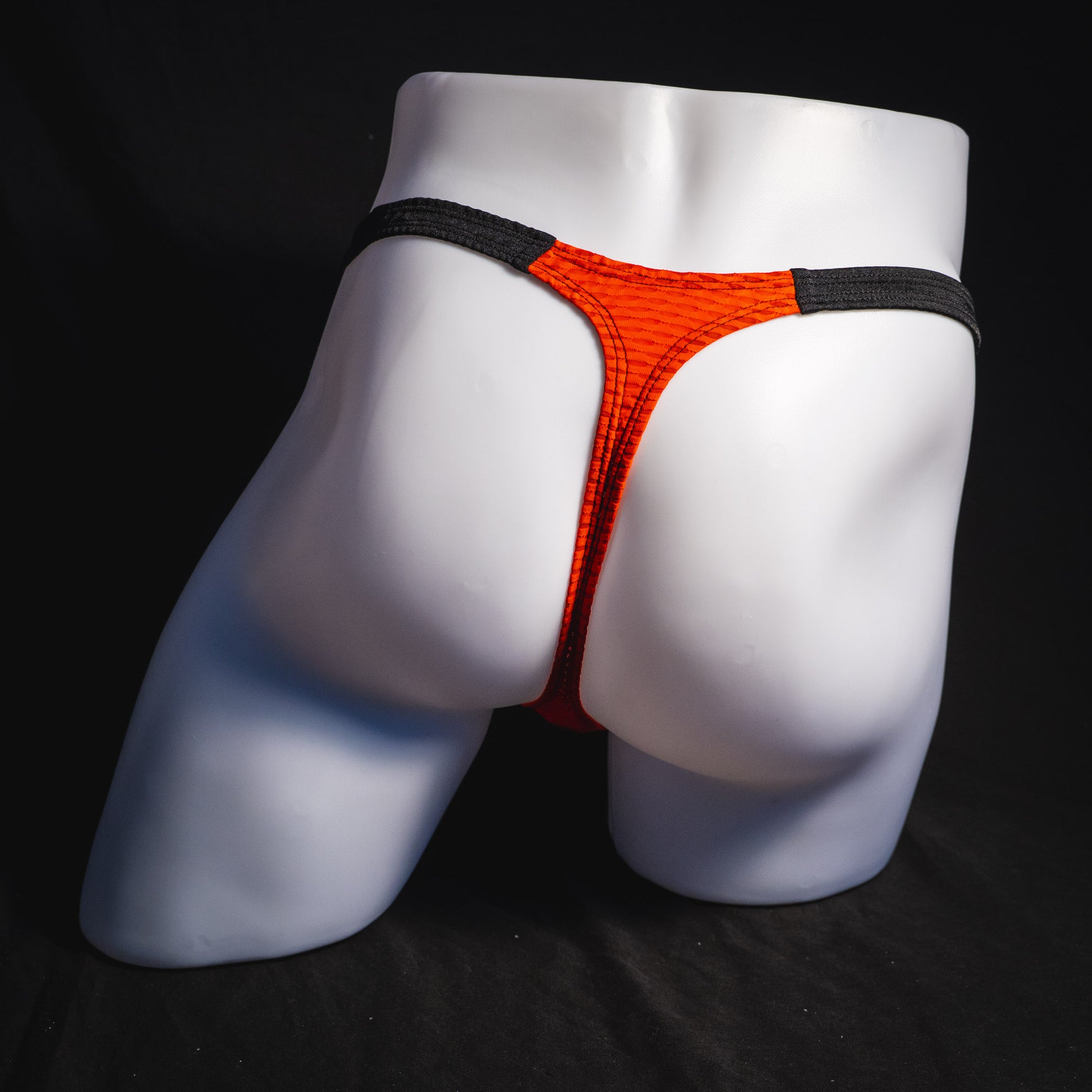 Men's red and black athletic mesh thong underwear, classic cut, full rear view.