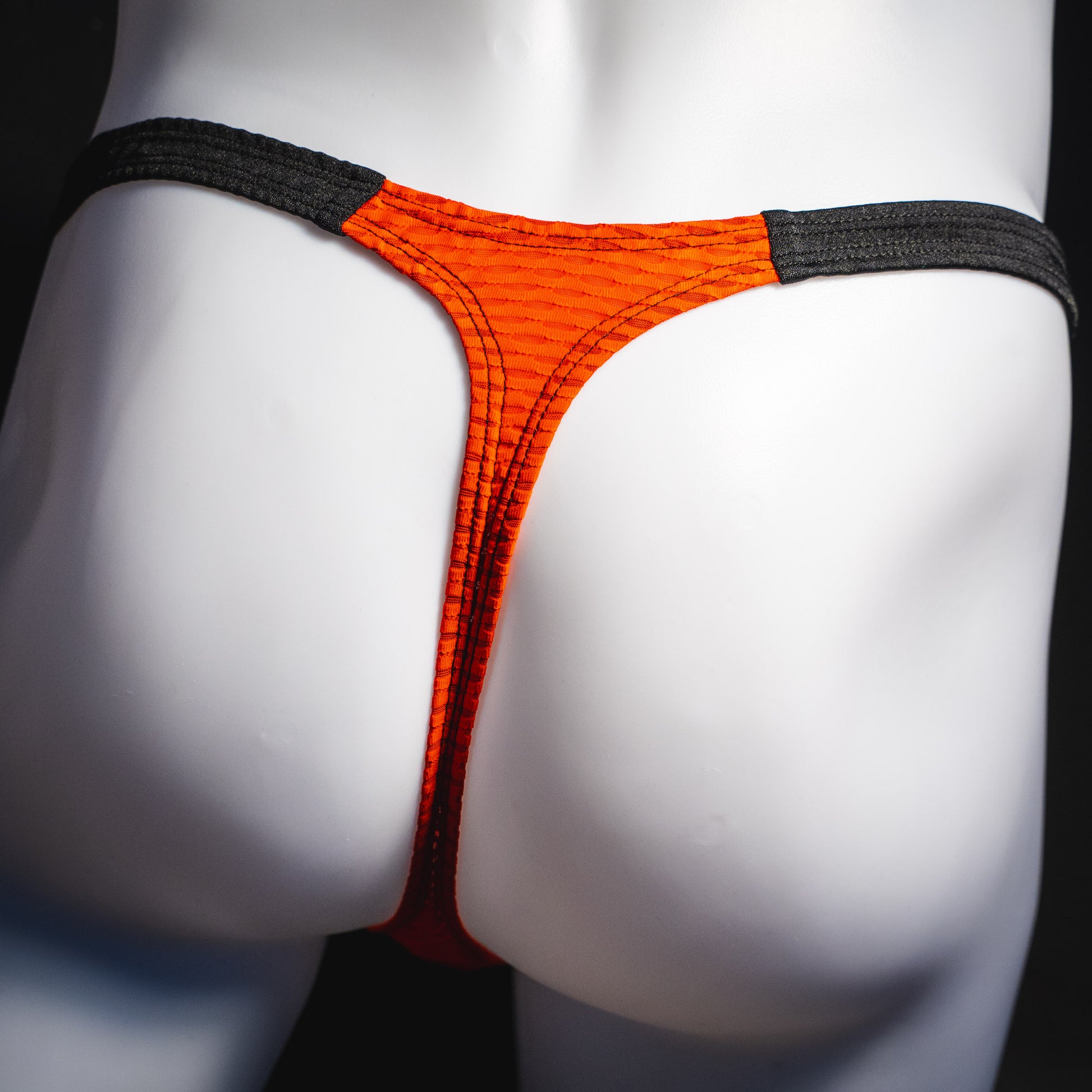 Men's red and black athletic mesh thong underwear, classic cut, rear view.