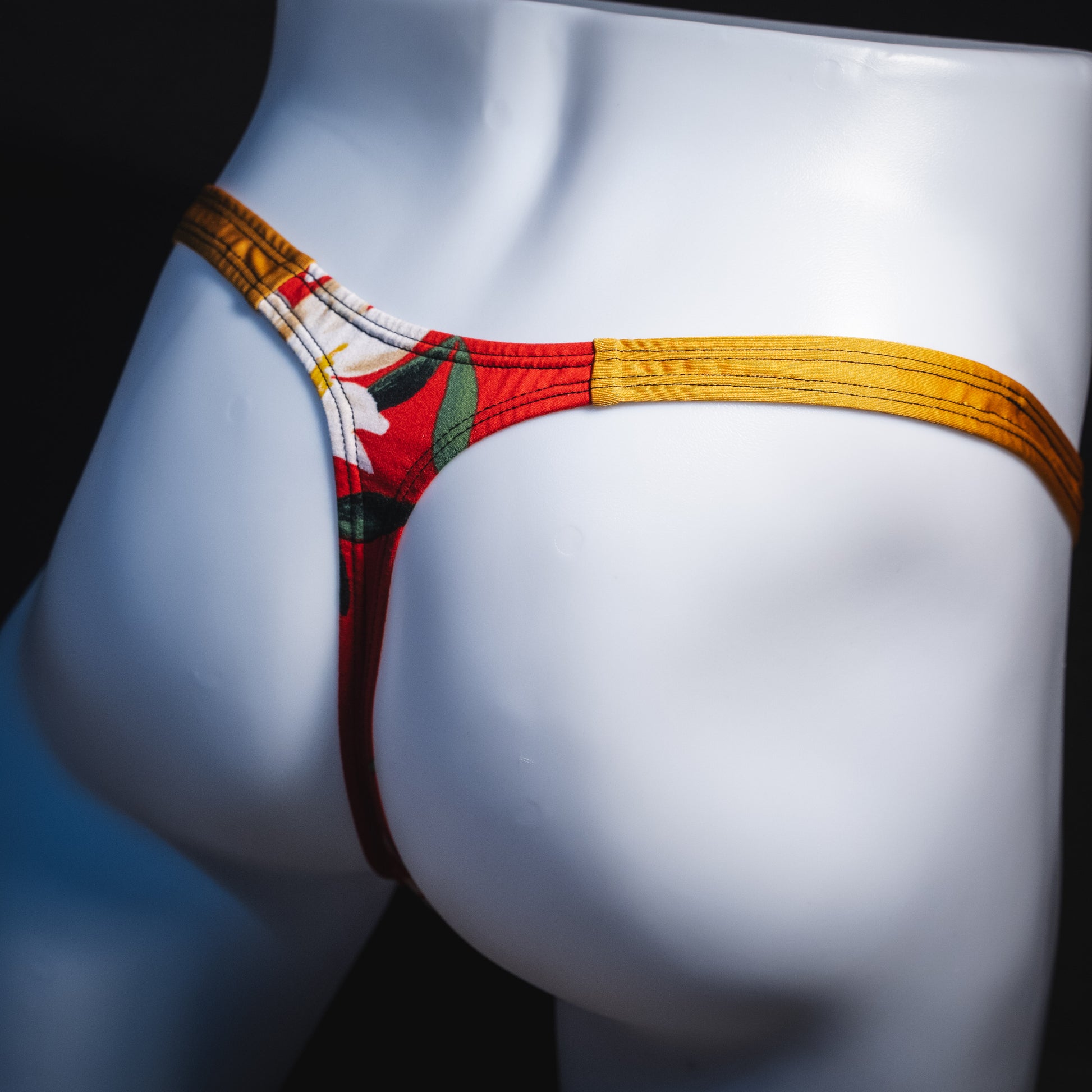 Men's red floral with gold straps thong underwear, classic cut, Angled rear view