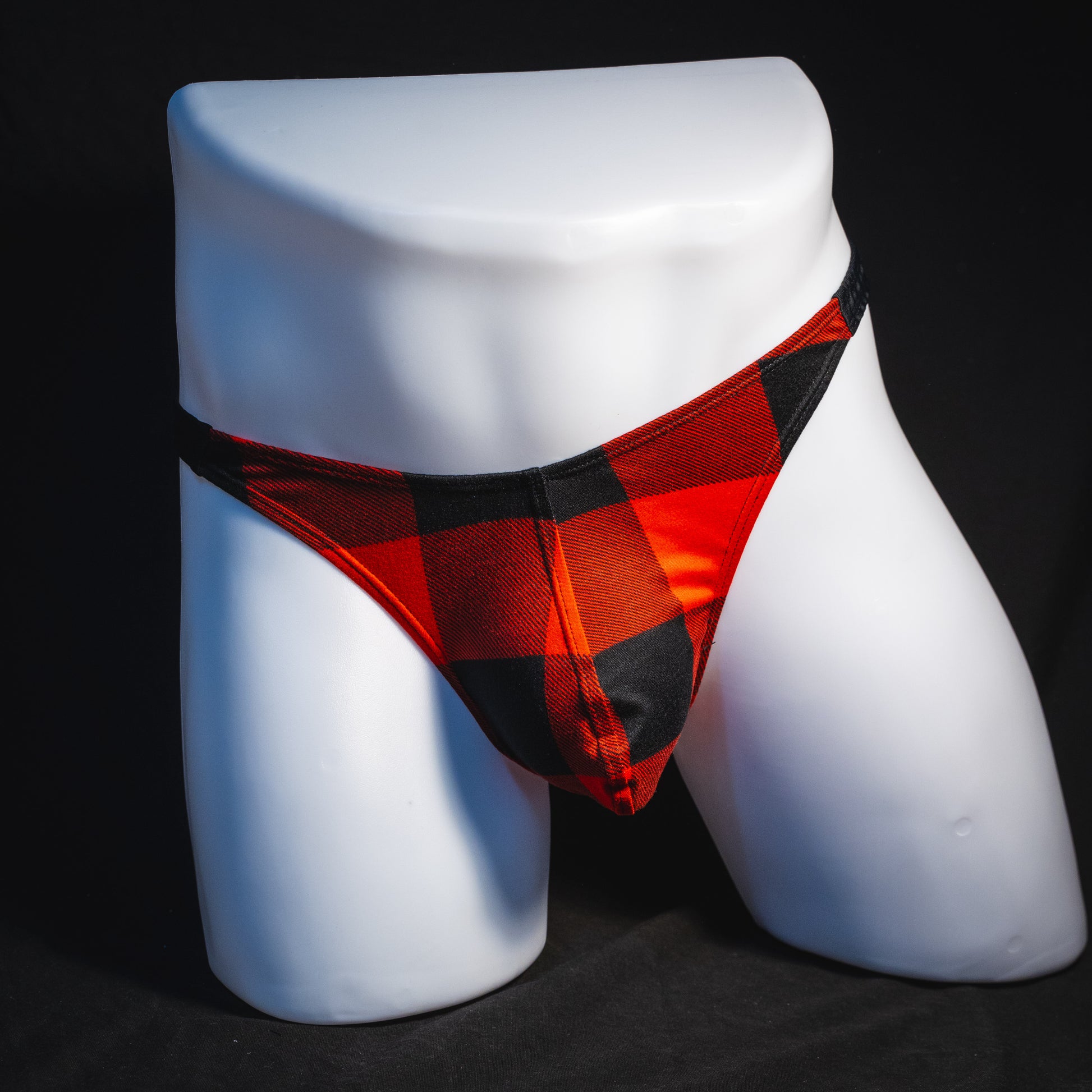 Men's red plaid with black straps thong underwear, classic cut, full front view.