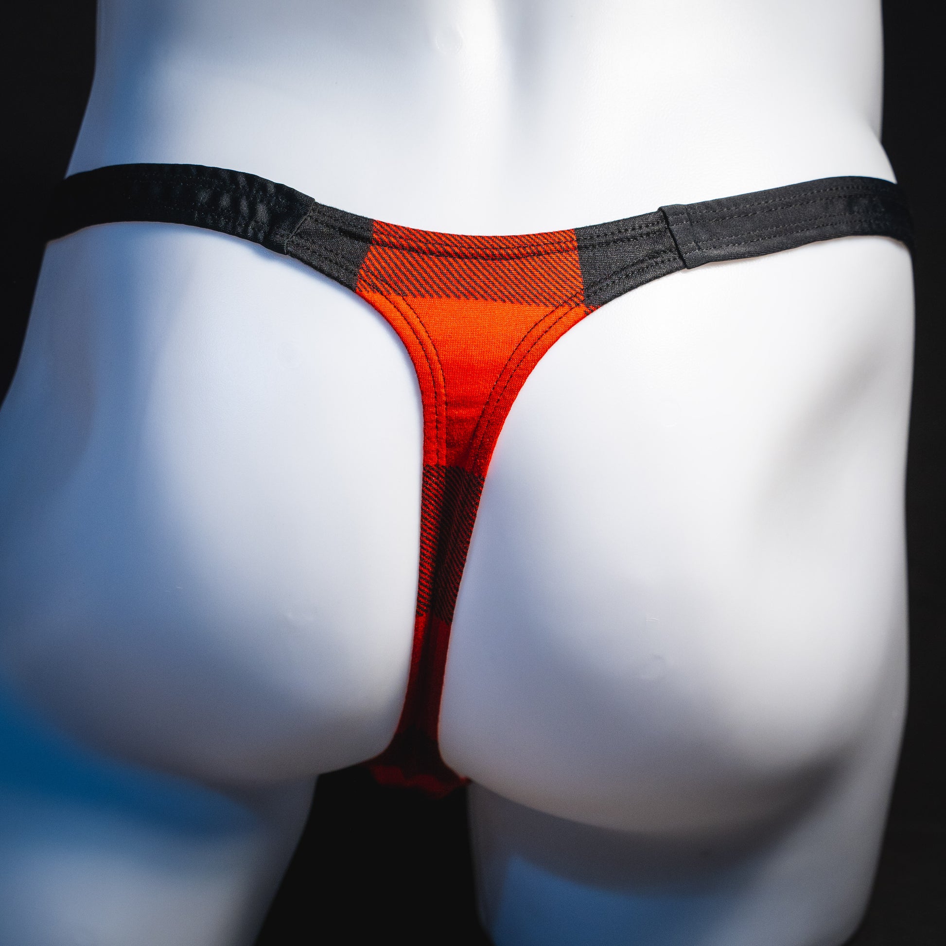Men's red plaid with black straps thong underwear, classic cut, rear view.