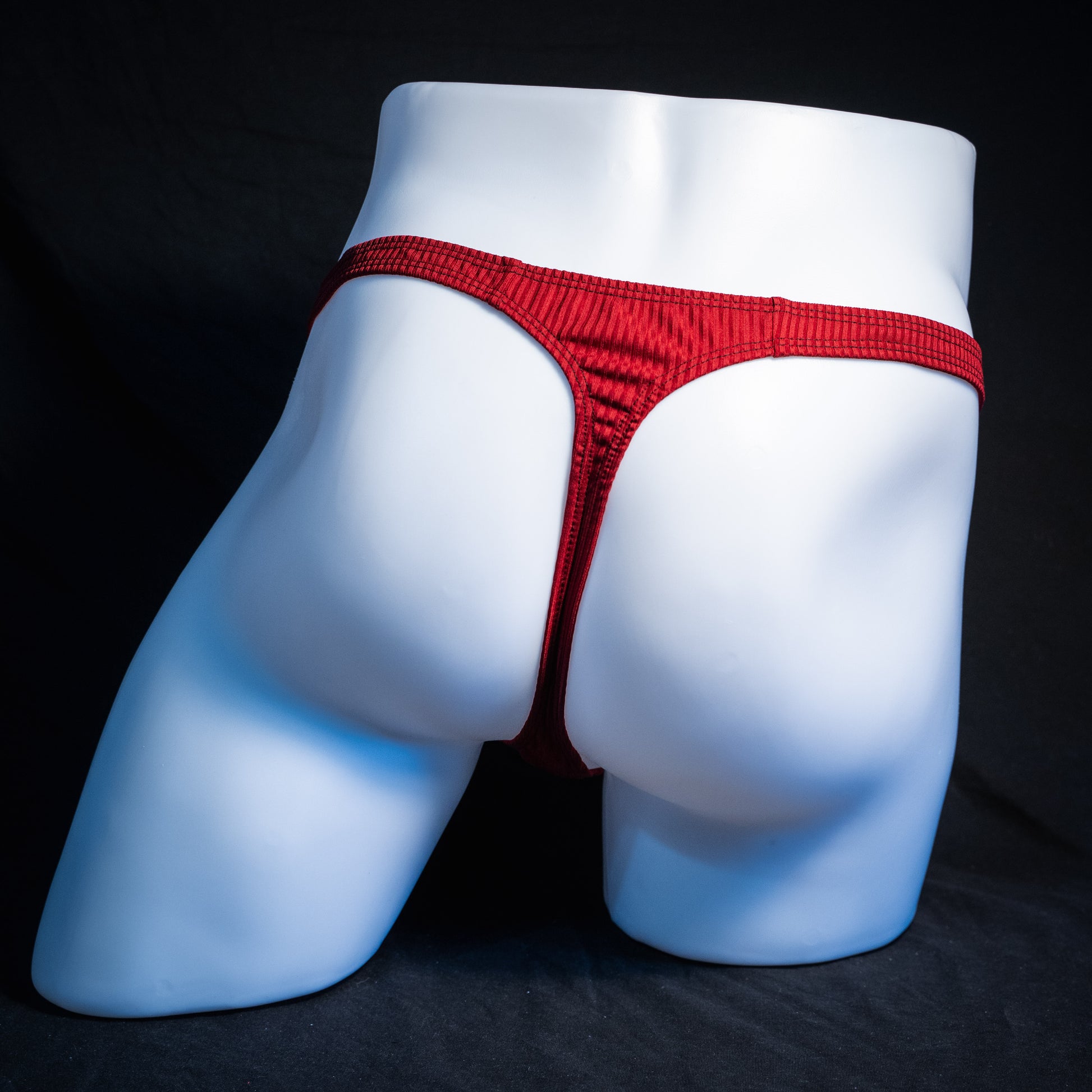 Men's ribbed red thong underwear, slim cut, rear view.