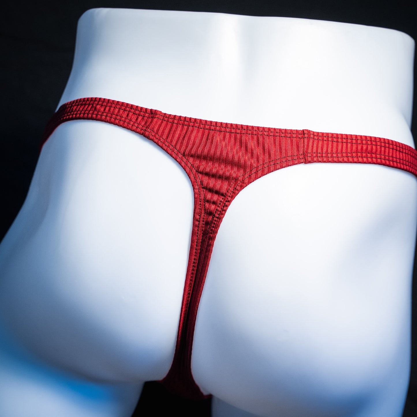 Men's ribbed red thong underwear, slim cut, rear view.