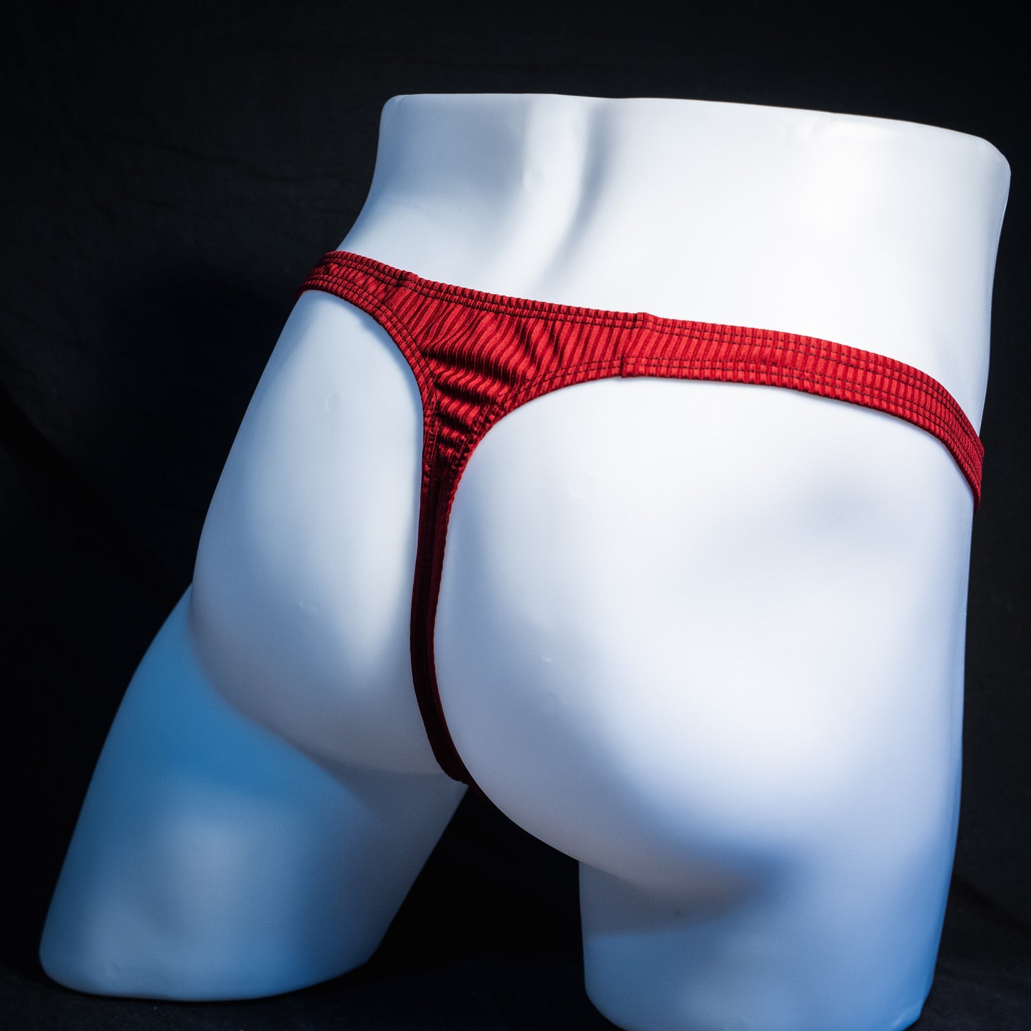 Men's ribbed red thong underwear, slim cut, rear view.