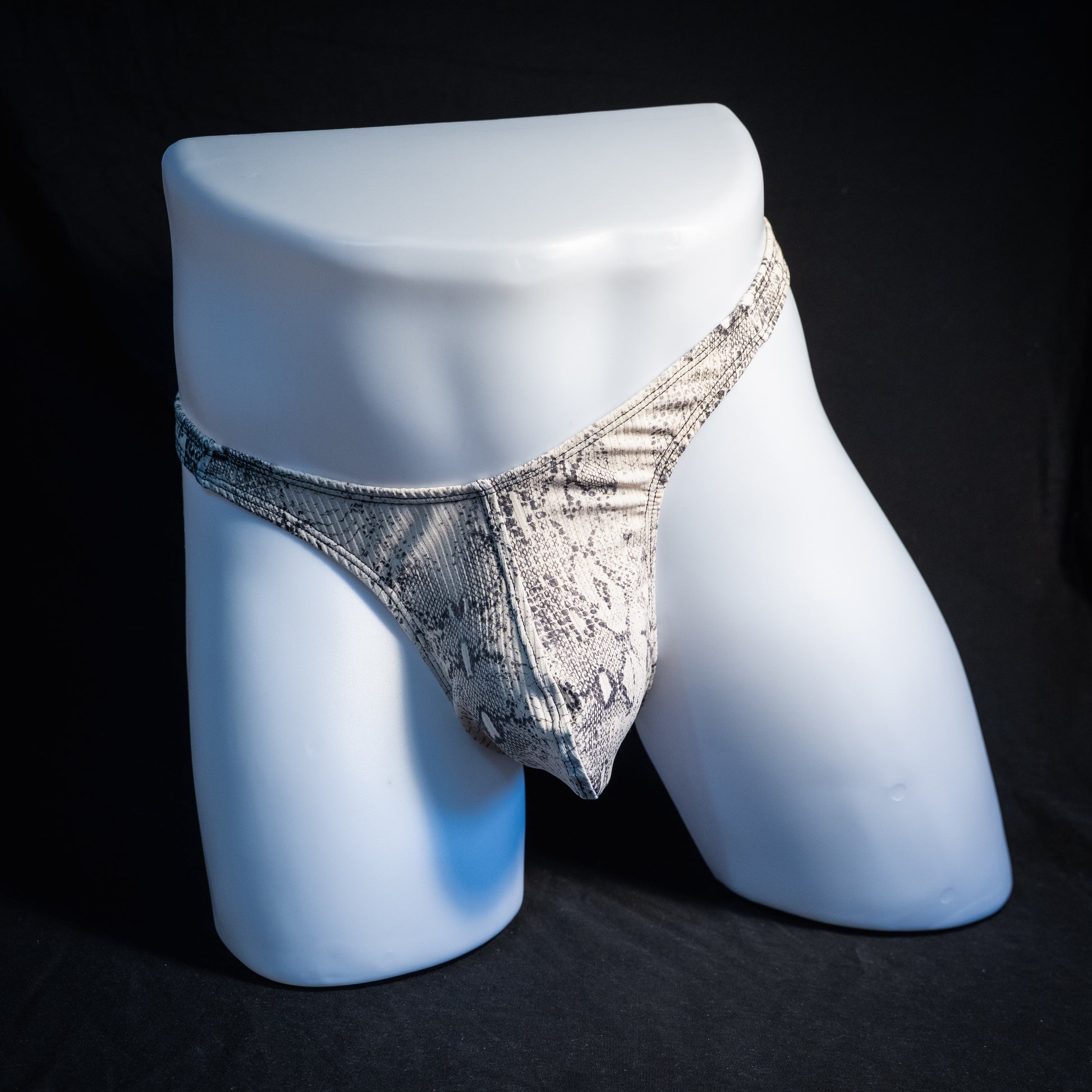 Men's beige snakeskin thong underwear, ribbed fabric, slim cut, front view.