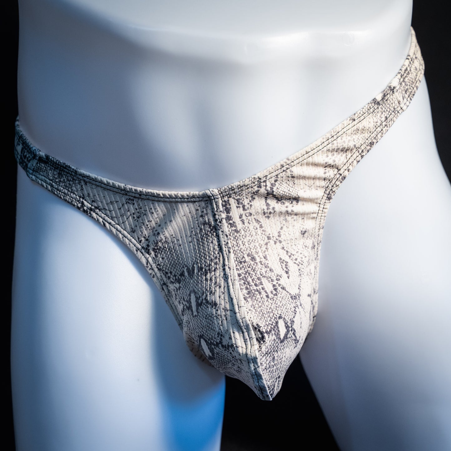 Men's beige snakeskin thong underwear, ribbed fabric, slim cut, front view.