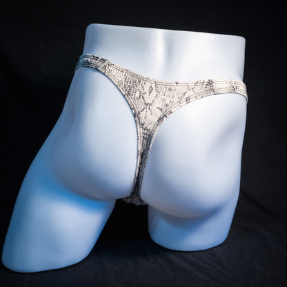 Men's beige snakeskin thong underwear, ribbed fabric, slim cut, rear view.