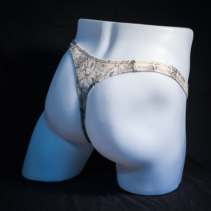 Men's beige snakeskin thong underwear, ribbed fabric, slim cut, rear view.