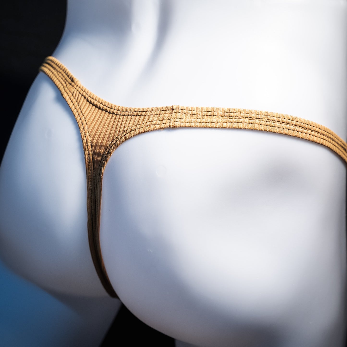 Men's ribbed gold thong underwear, classic cut, rear view.