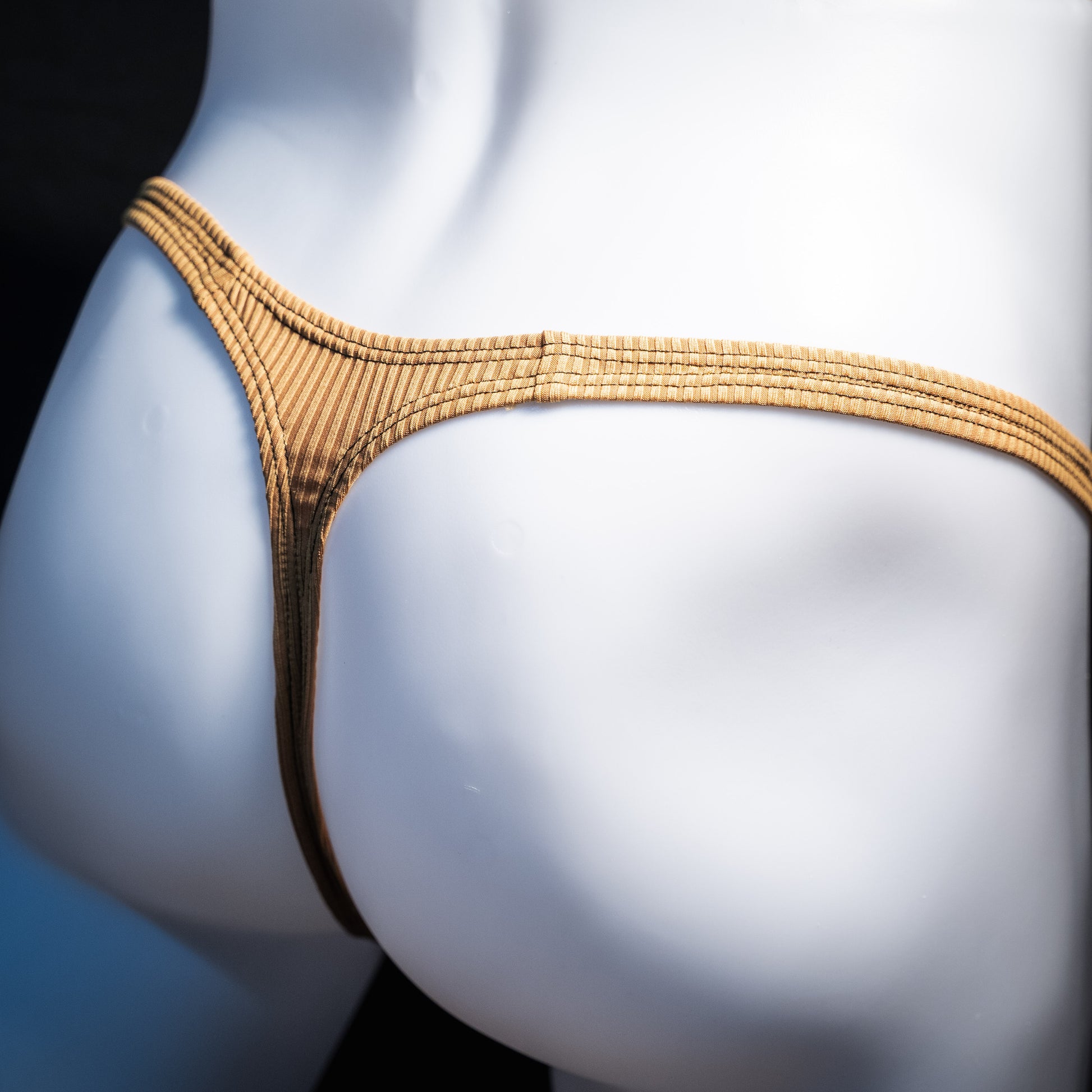 Men's ribbed gold thong underwear, classic cut, rear view.