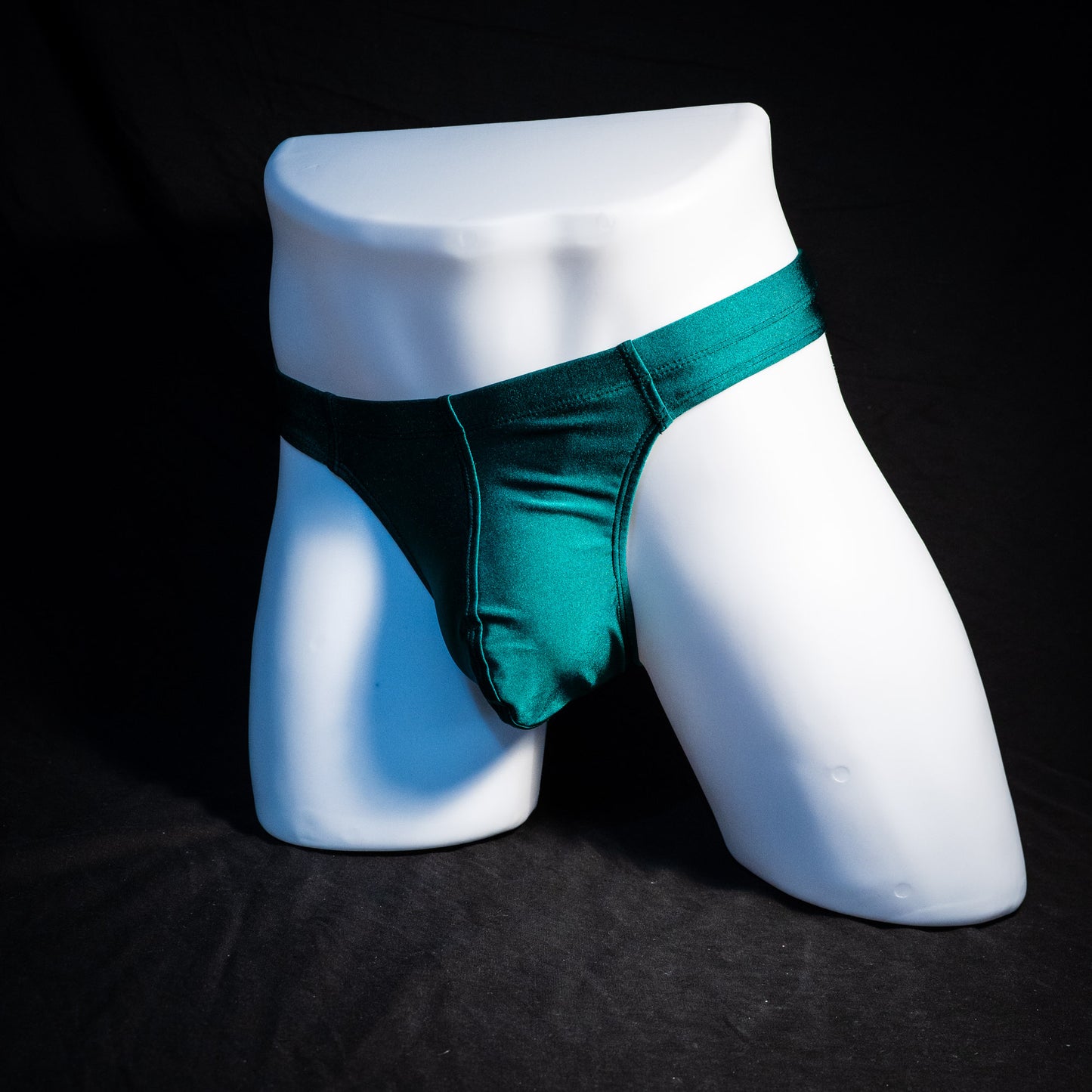 Men's forest green thong underwear, full front angled view.