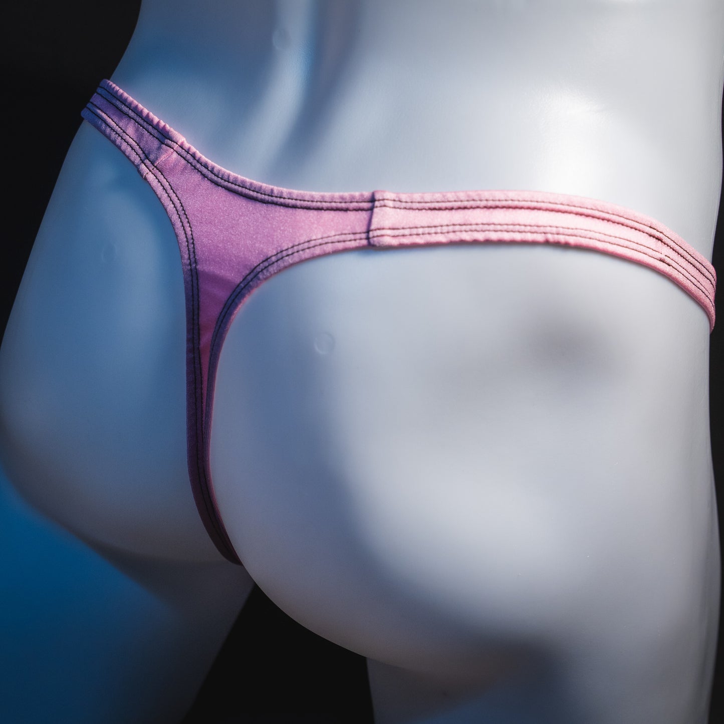 Men's rose pink thong underwear, classic cut, angled rear view.