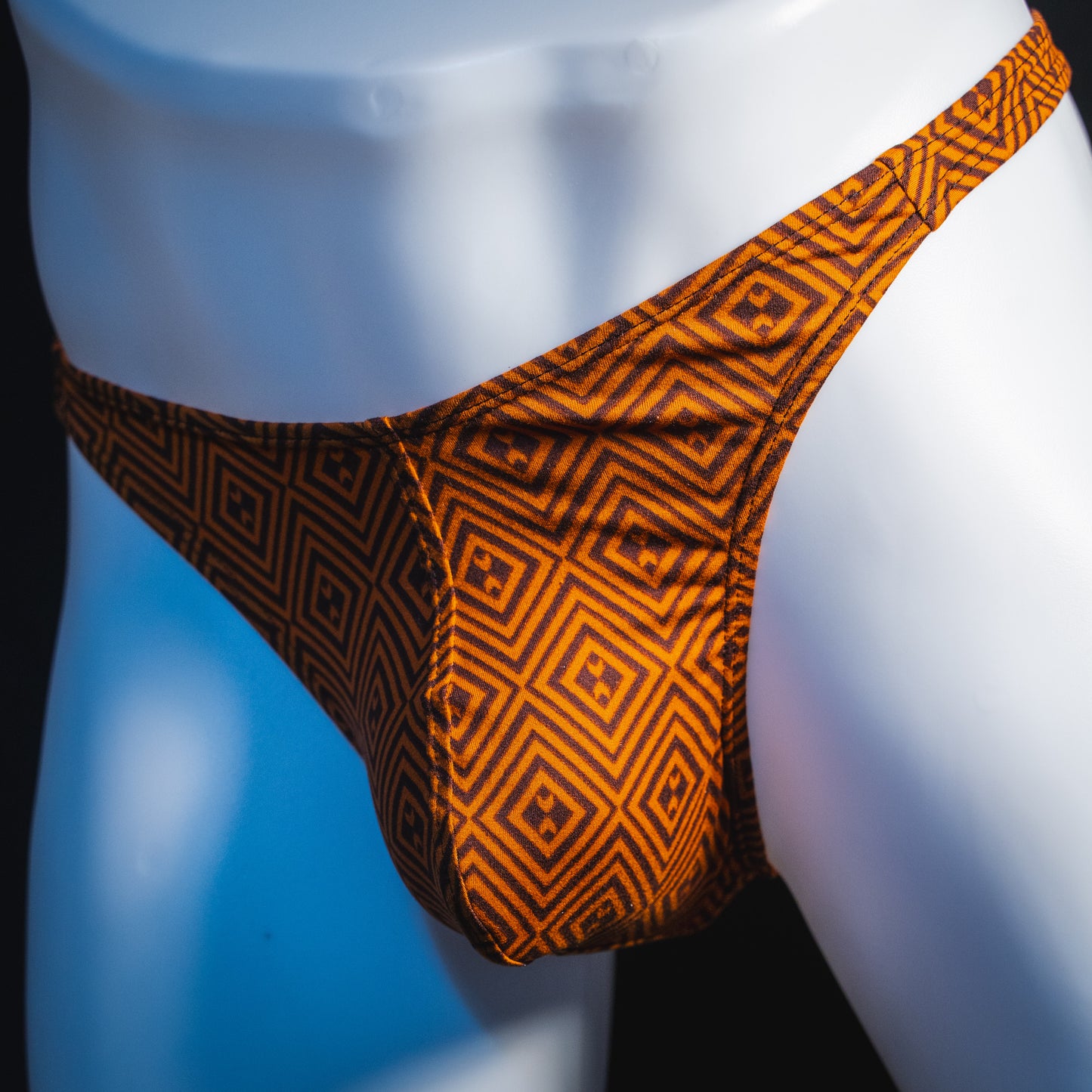 Men's geometric rust thong underwear, classic cut, angled front view.
