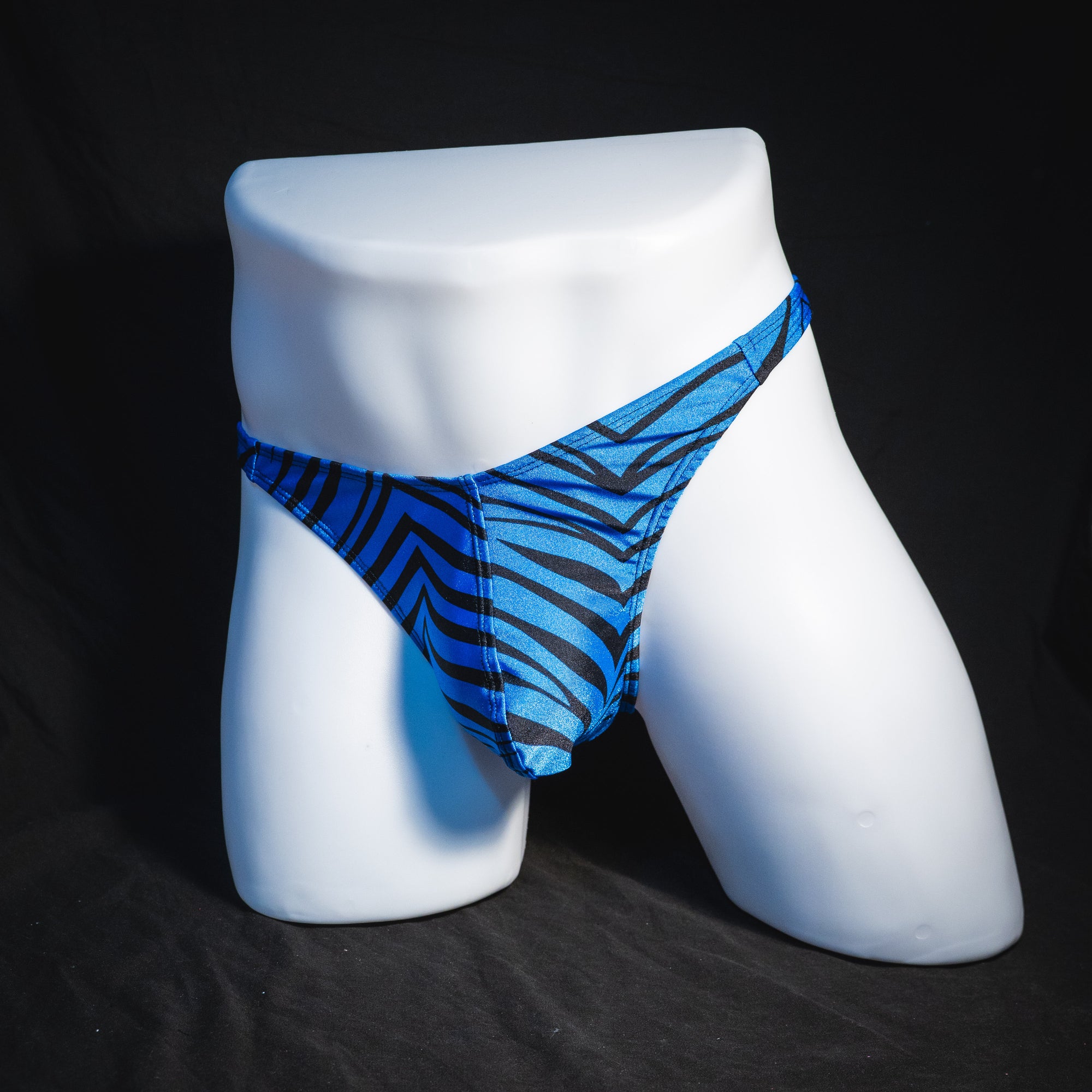 Men's shiny blue zebra stripe thong underwear, classic cut,  full angled view.