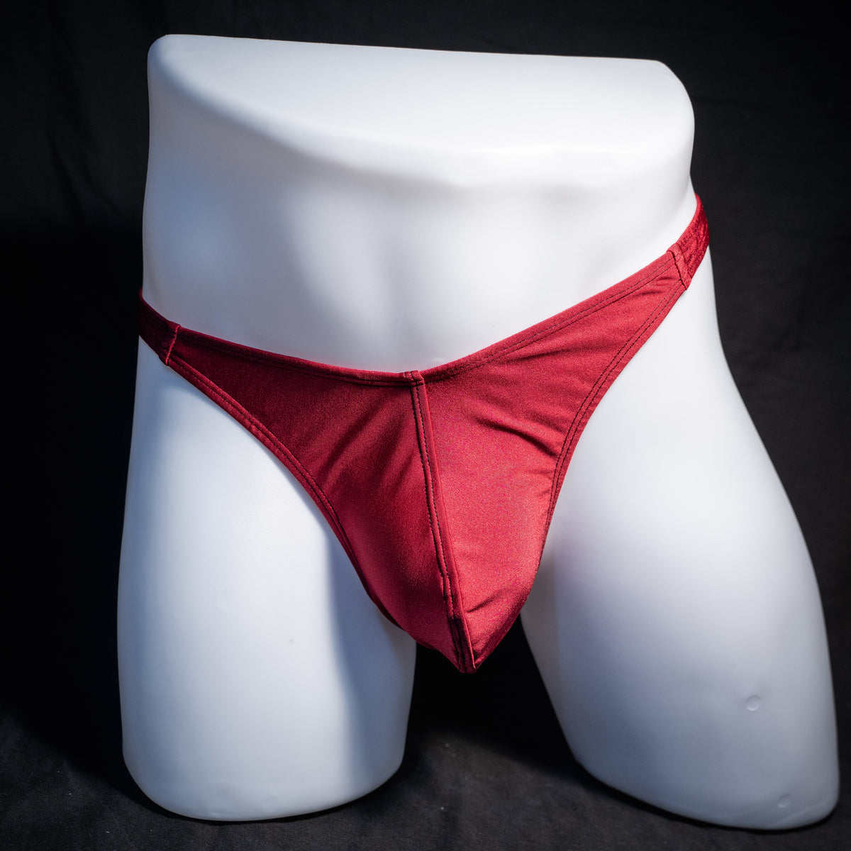 Men's solid maroon red thong underwear, classic cut, front view.