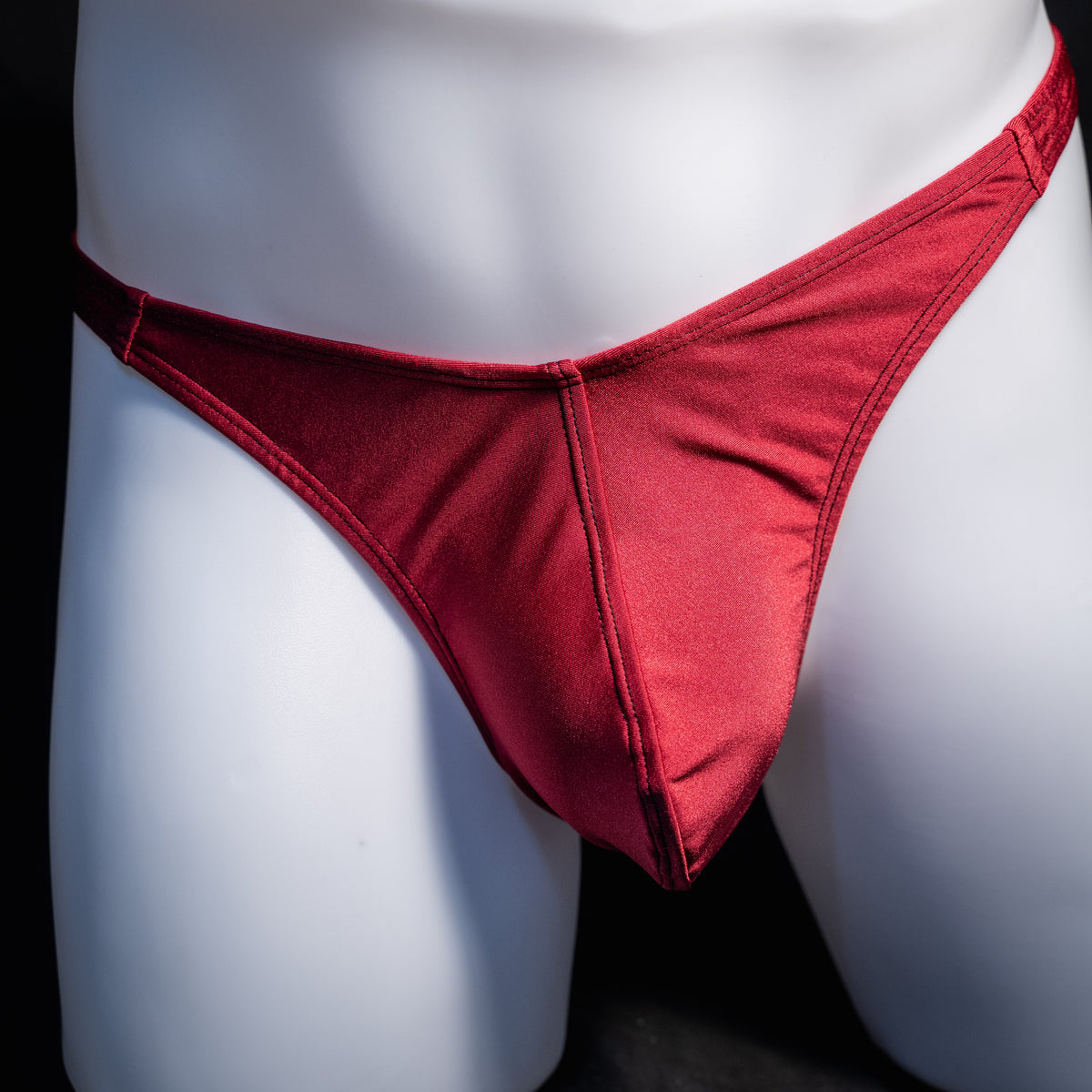 Men's solid maroon red thong underwear, classic cut, front view.