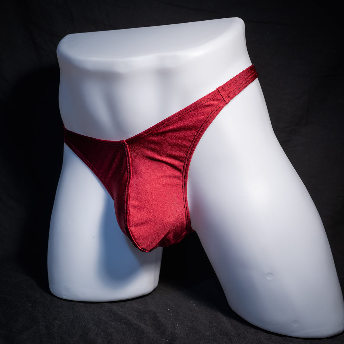 Men's solid maroon red thong underwear, classic cut, front view.