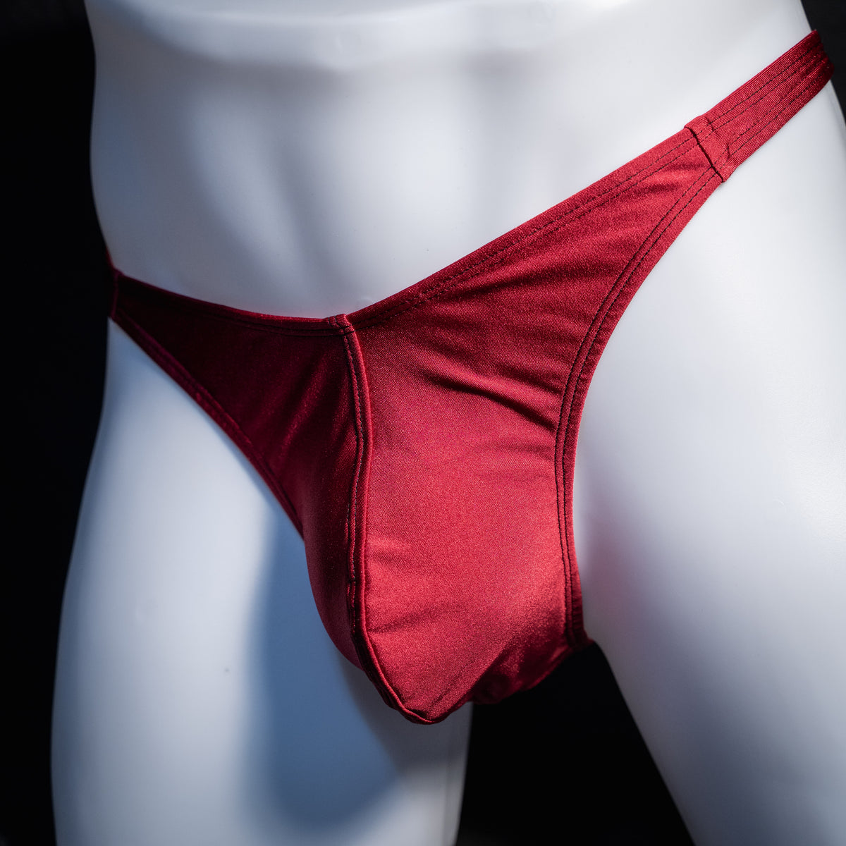 Men's solid maroon red thong underwear, classic cut, front view.
