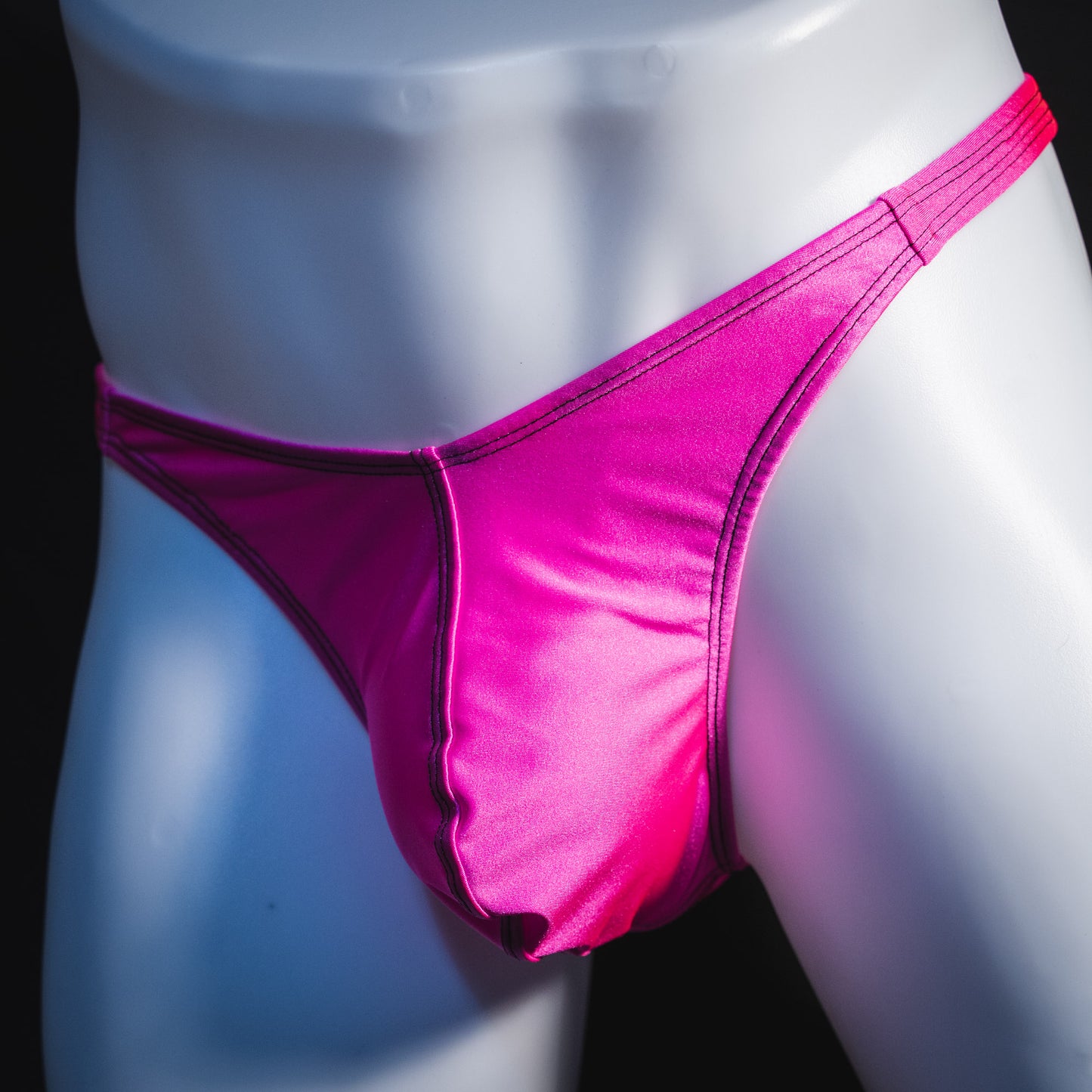 Men's solid pink thong underwear, classic cut, angled front view.